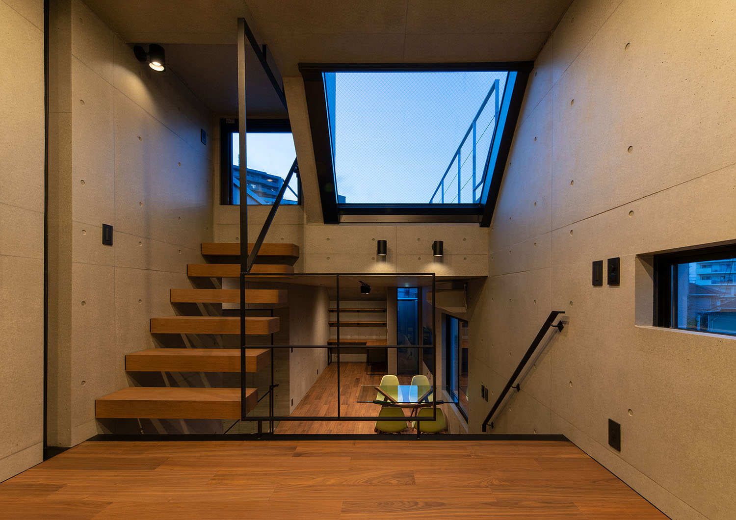 壁に取り付けられたスポットライトと天窓からの明かりがスキップフロアを照らす・デザイン住宅 注文住宅・デザイン住宅建築実例_『CASE691 MateriaBox』_LDK