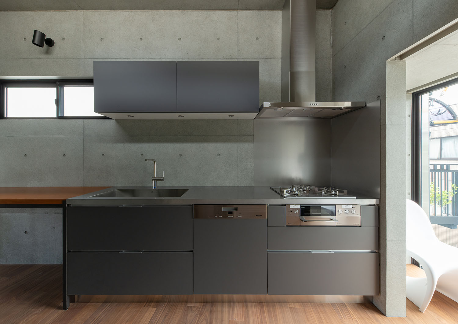 コンクリートの壁に付けられているグレーのキッチン・デザイン住宅 注文住宅・デザイン住宅建築実例_『CASE691 MateriaBox』_キッチン