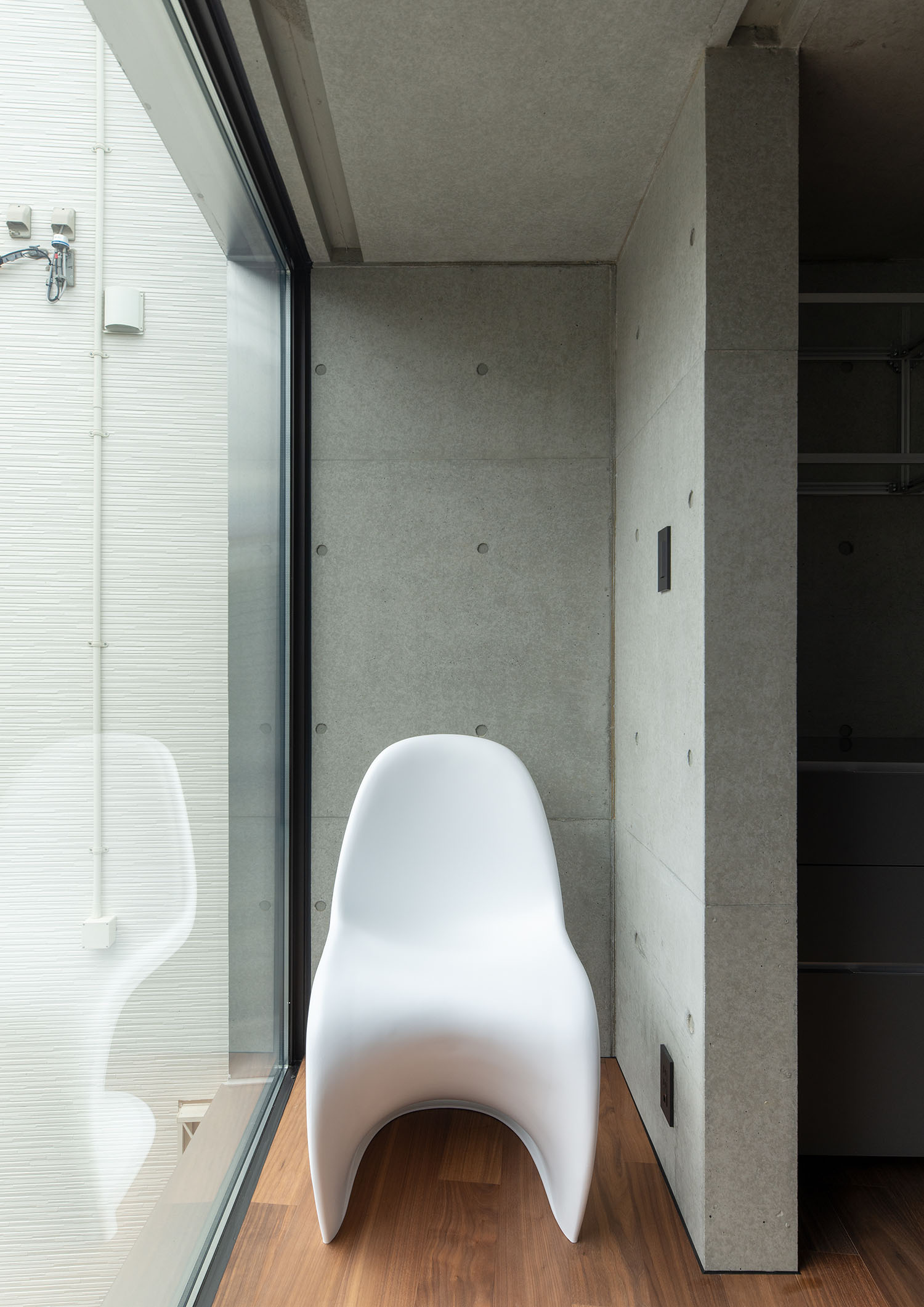 窓とコンクリートの壁に囲まれた場所にある白い椅子・デザイン住宅 注文住宅・デザイン住宅建築実例_『CASE691 MateriaBox』_キッチン