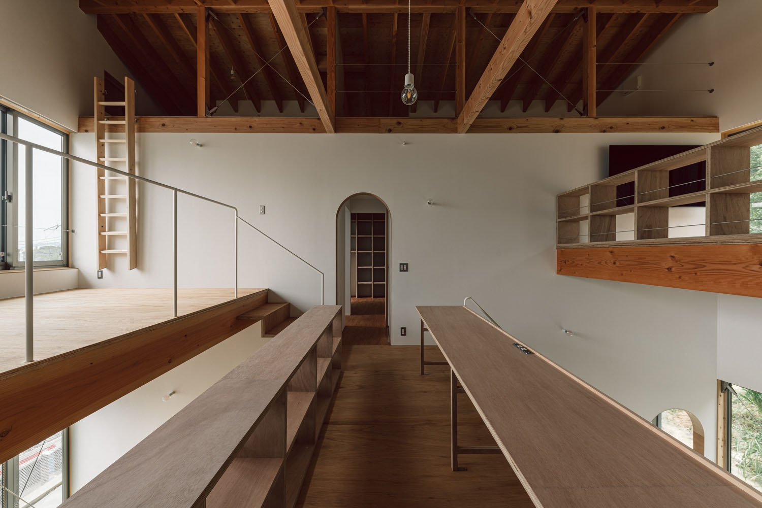 吹き抜けに面したデスクスペースがあるスキップフロアにアーチ壁が設けられた様子・デザイン住宅 注文住宅・デザイン住宅建築実例_『CASE692 桜ヶ丘の住宅』_LDK