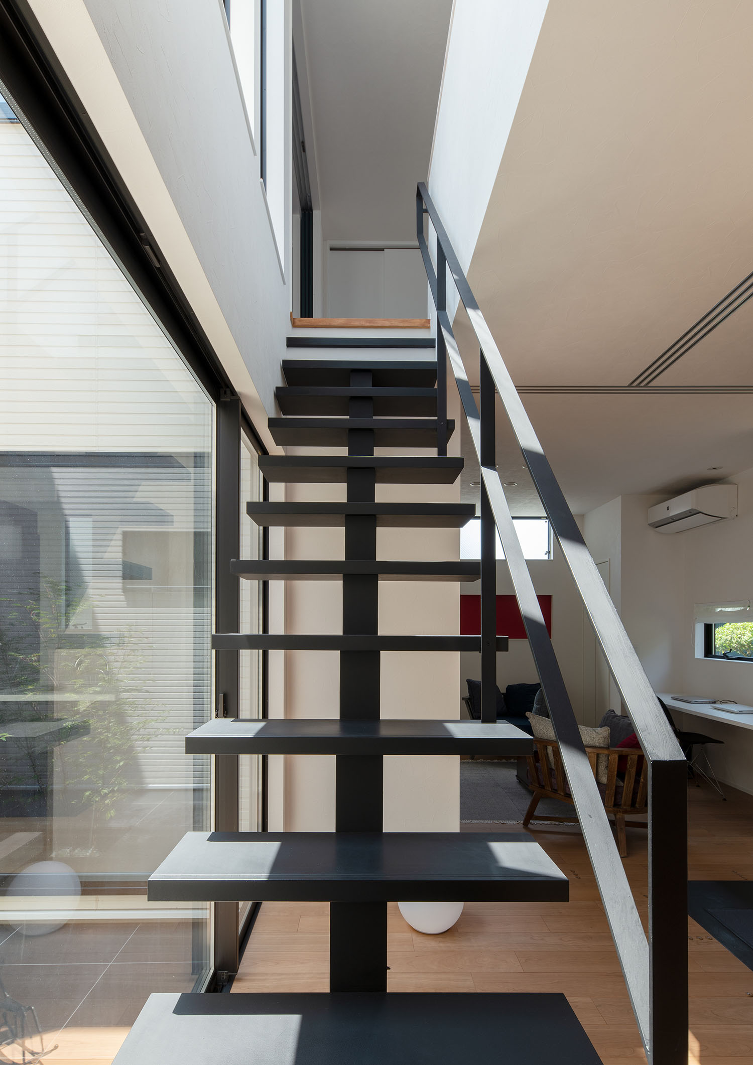 窓のそばに設けられた黒いスケルトン階段・デザイン住宅 注文住宅・デザイン住宅建築実例_『CASE693 "CONNECT"』_階段