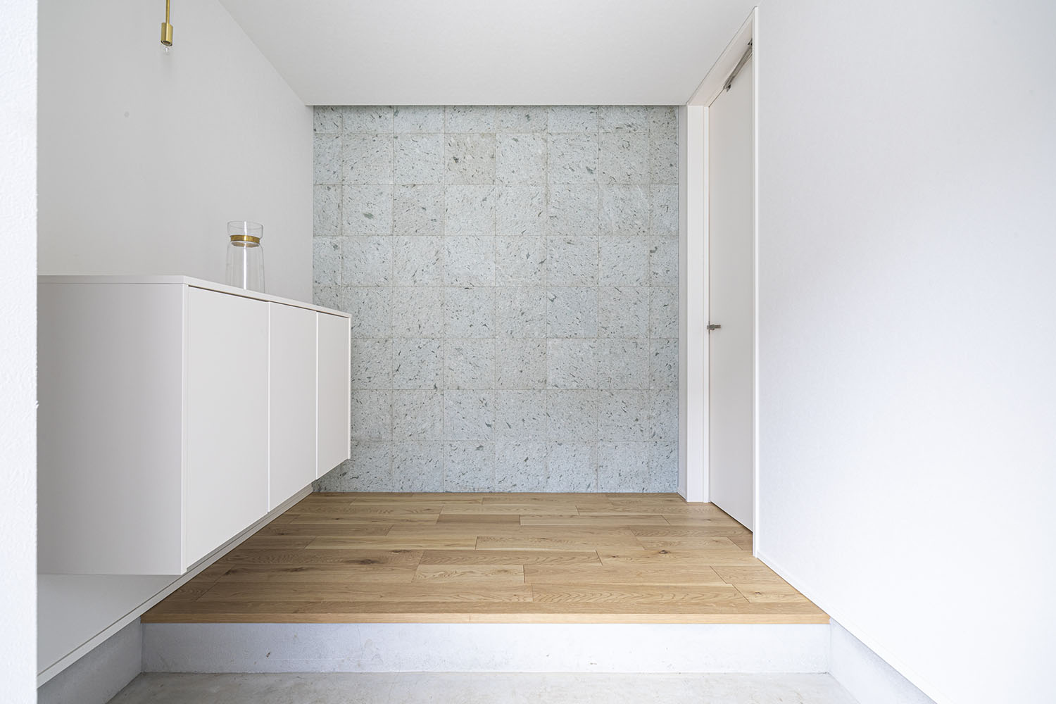 正面が石の壁になった、浮き収納のある玄関・デザイン住宅 注文住宅・デザイン住宅建築実例_『CASE694 Veil』_玄関