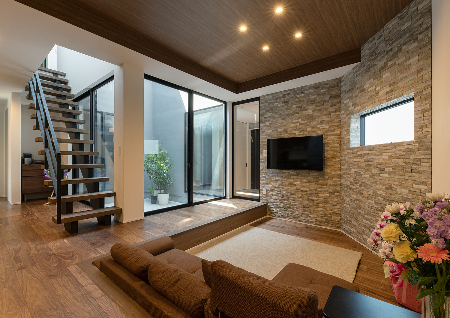 タイルのアクセントウォールにテレビやスリット窓が取り付けられたダウンリビング・デザイン住宅 注文住宅・デザイン住宅建築実例_『CASE695 メガホンハウス』_LDK