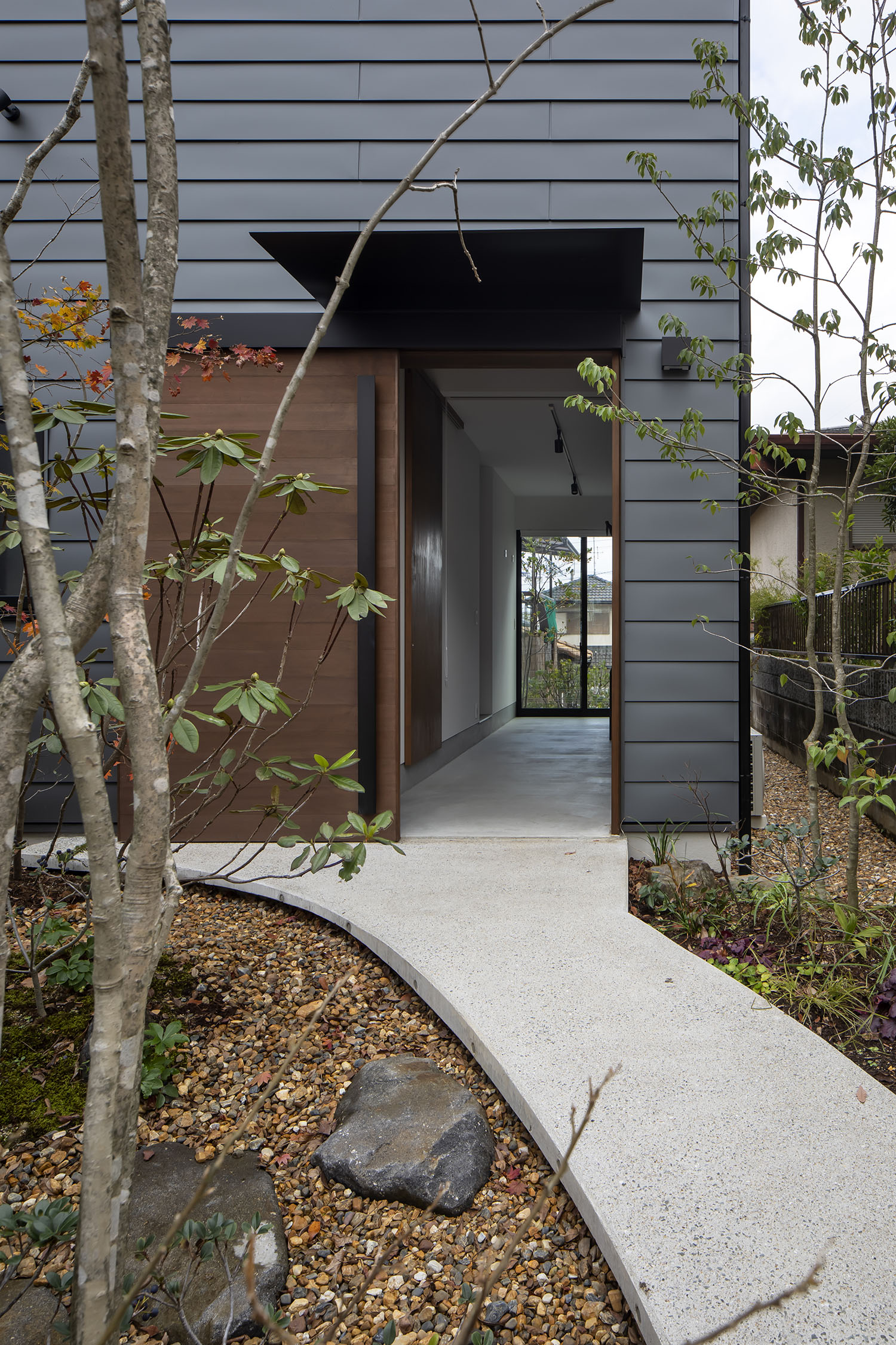 木の引き戸が開いた先に、土間が広がっている様子・デザイン住宅 注文住宅・デザイン住宅建築実例_『CASE698 「景の家」』_外観