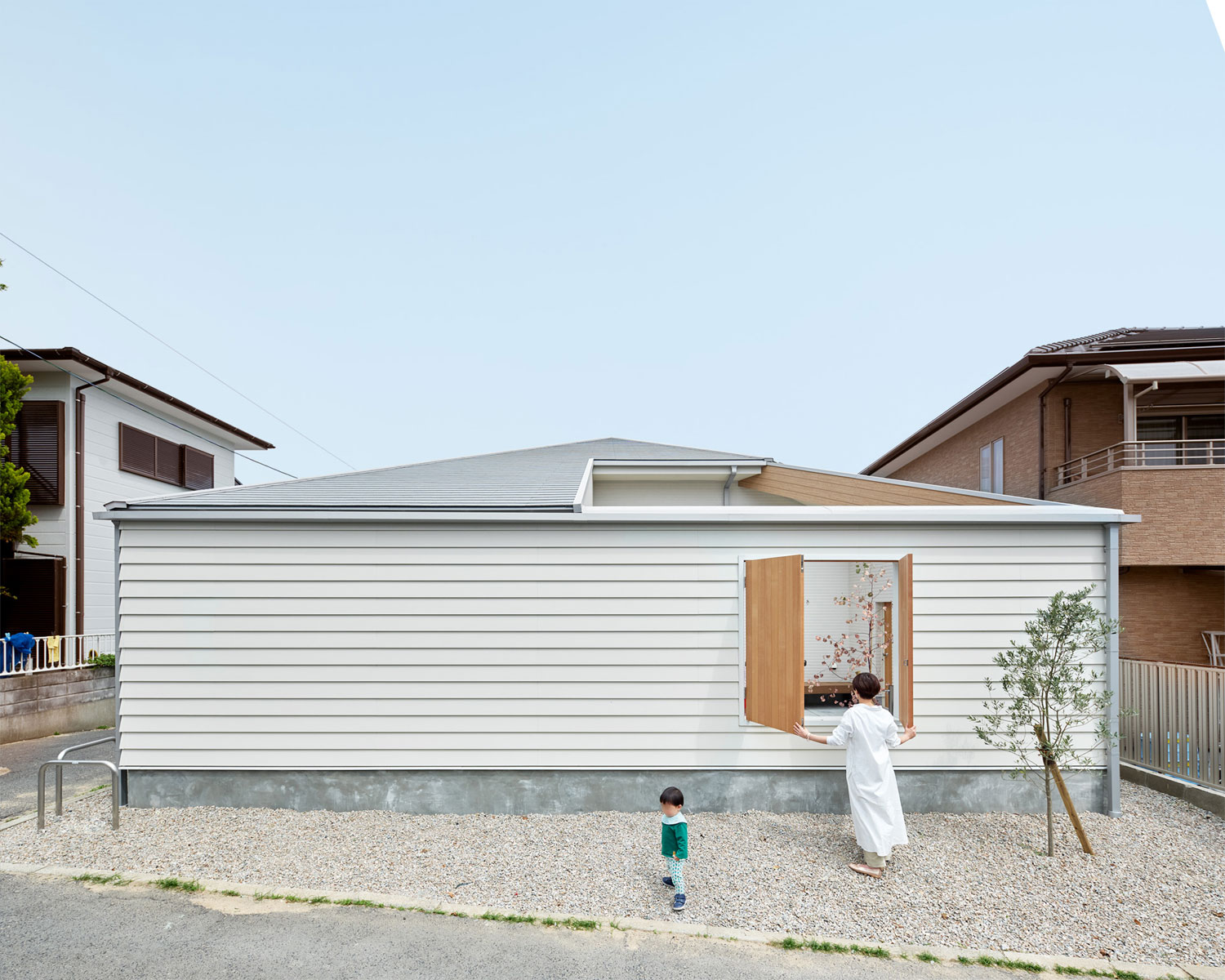 外壁に木製の開き戸を設けたおしゃれな平屋の外観