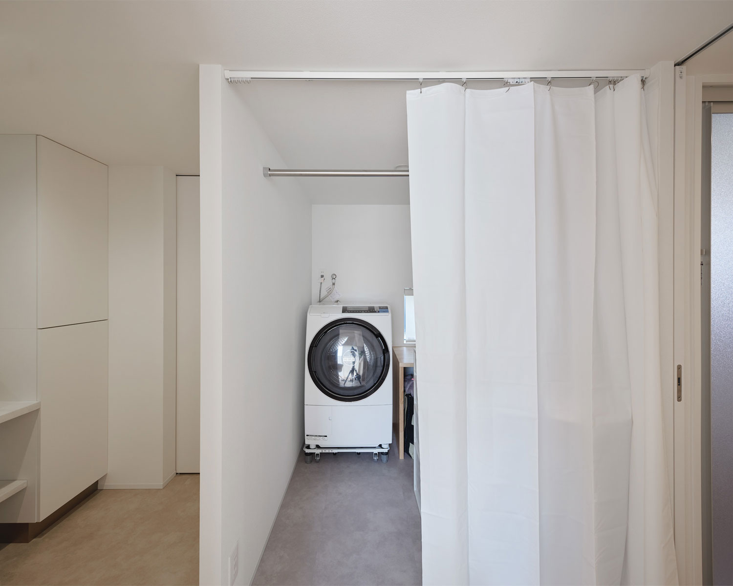 カーテンで仕切ったフレキシブルなランドリールーム