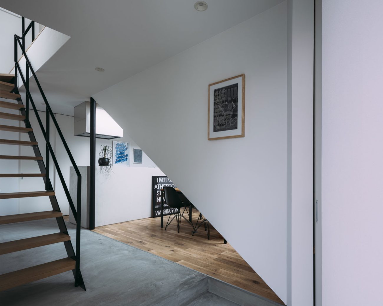 モルタルの玄関を入るとすぐにスケルトン階段やリビングが見える様子・フリーダムアーキテクツの事例 注文住宅・デザイン住宅建築実例_『CASE703 /』_玄関