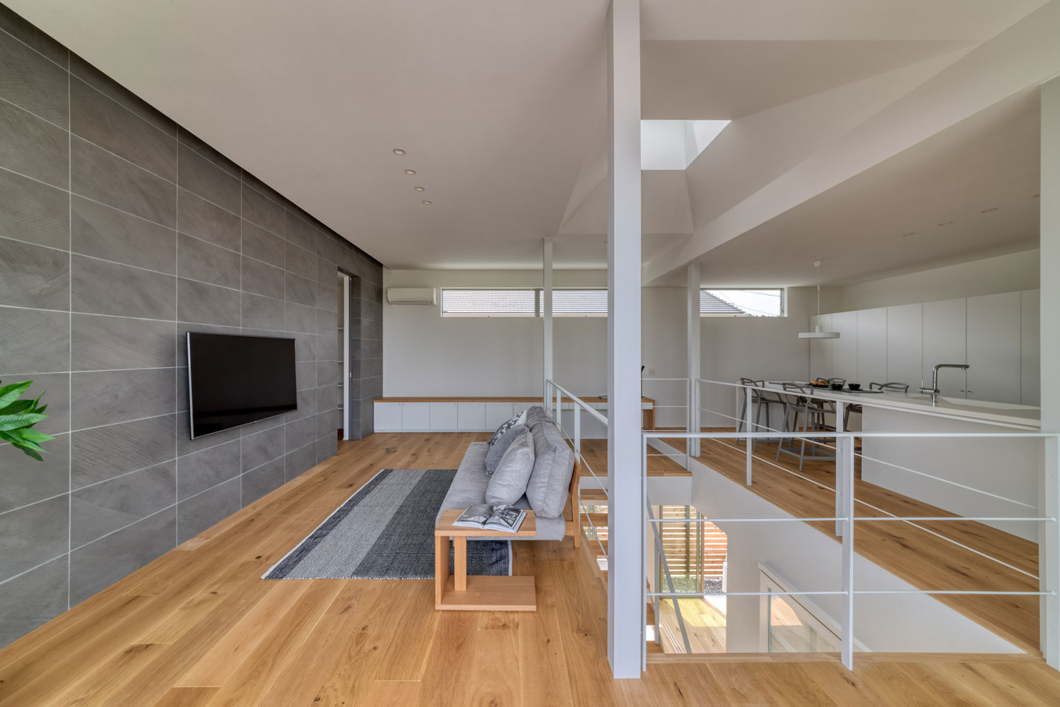 白を基調とし、グレーのインテリアやアクセントウォールがアクセントになったLDK・フリーダムアーキテクツの事例 注文住宅・デザイン住宅建築実例_『CASE704 with a view』_LDK