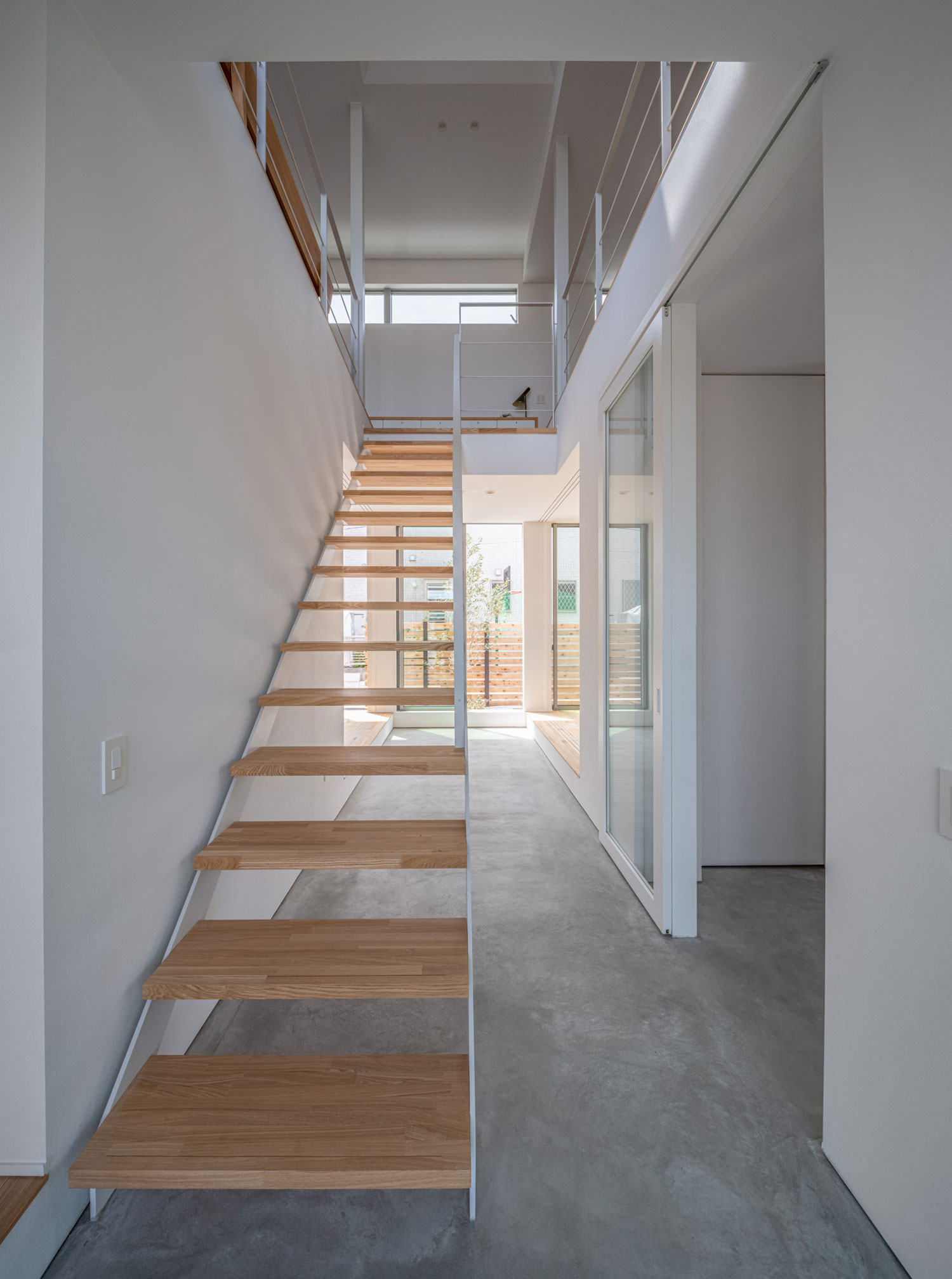 モルタルの玄関と繋がる木製のスケルトン階段・フリーダムアーキテクツの事例 注文住宅・デザイン住宅建築実例_『CASE704 with a view』_階段