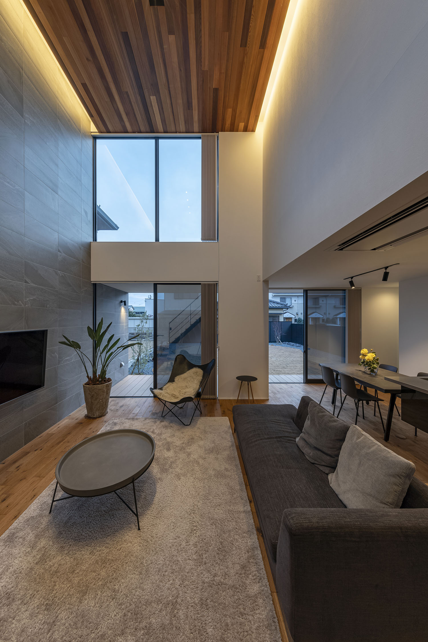 天井の間接照明に照らされた吹き抜けのあるリビング・フリーダムアーキテクツの事例 注文住宅・デザイン住宅建築実例_『CASE709 sumika』_LDK