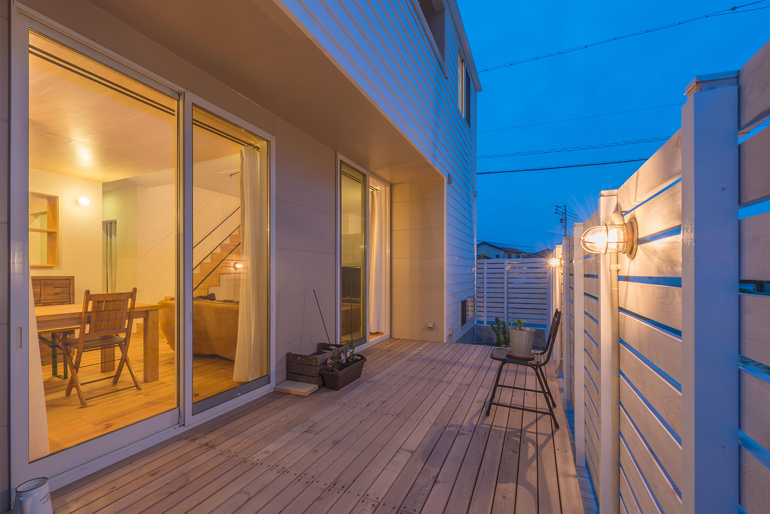 目隠し壁を取り付けたLDKに面したウッドデッキのテラス・デザイン住宅