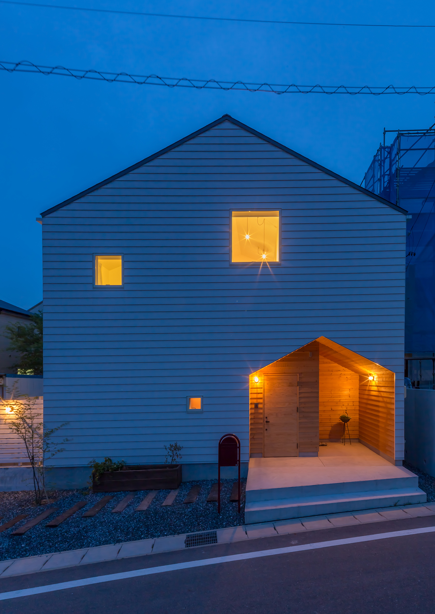 三角屋根の形にくりぬかれたエントランスがある三角屋根の家・デザイン住宅
