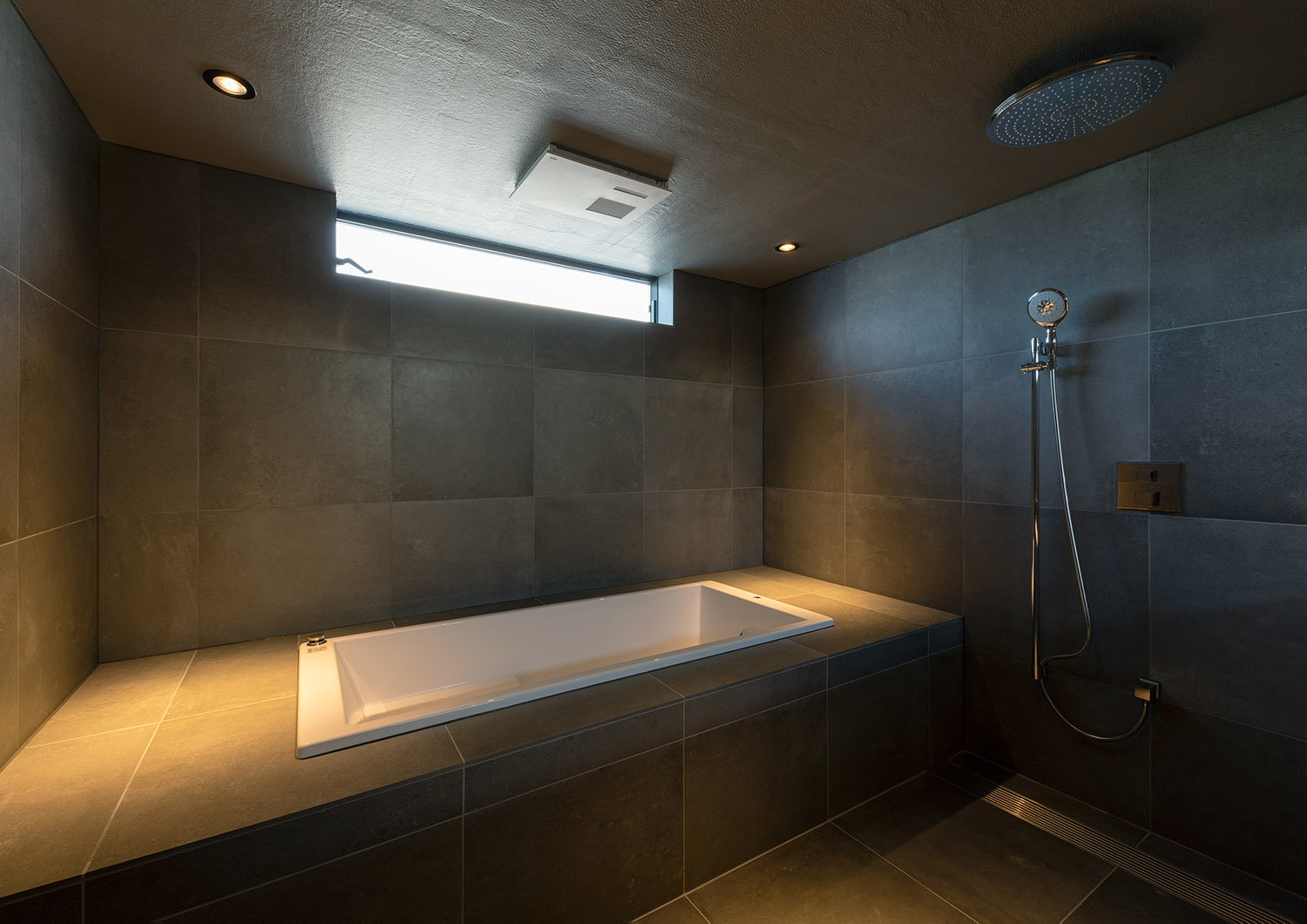 注文住宅・浴室・タイル・グレー・スリット窓・オーバーヘッドシャワー 注文住宅・デザイン住宅建築実例_『CASE744 CAVE』_浴室・洗面所