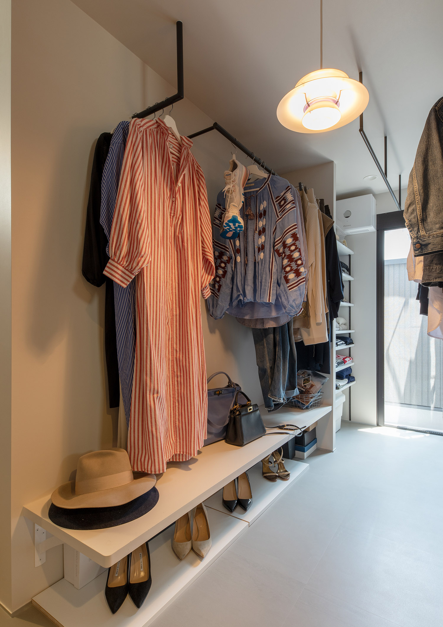 洋服が多くかけられている、白を基調としたウォークインクローゼット・フリーダムアーキテクツの事例 注文住宅・デザイン住宅建築実例_『CASE748 バスケットコートのある家』_寝室