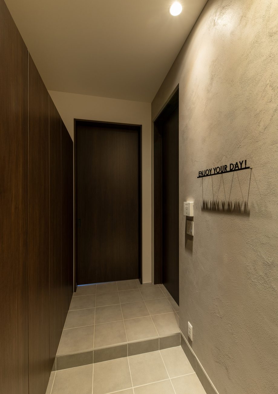 切文字のステンレスサインがある塗り壁の玄関・フリーダムアーキテクツの事例 注文住宅・デザイン住宅建築実例_『CASE748 バスケットコートのある家』_玄関