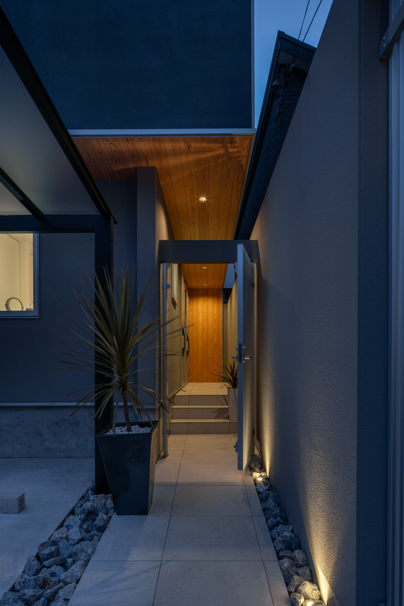 門扉の向こう側に木の軒天井やタイルの階段があるアプローチ・デザイン住宅 注文住宅・デザイン住宅建築実例_『CASE749 dignified housing』_外観