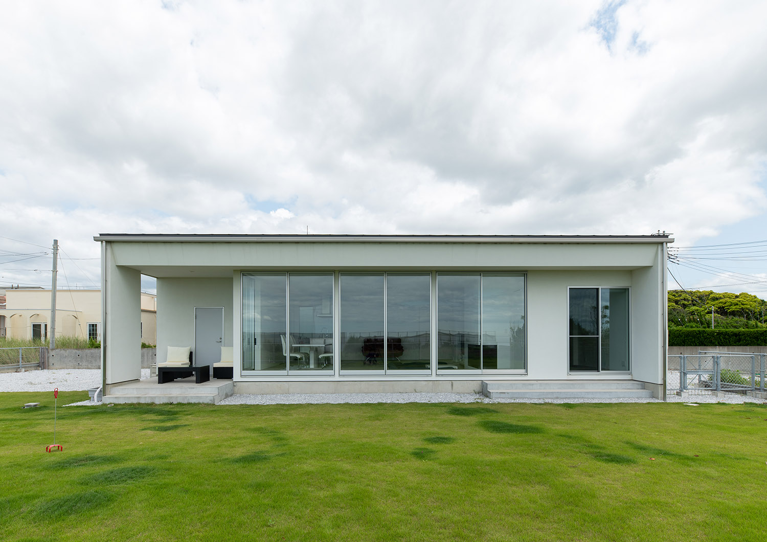 芝生の庭に面した大きな窓がある、白い外壁の平屋住宅・デザイン住宅 注文住宅・デザイン住宅建築実例_『CASE750 WHITE　GATE』_外観