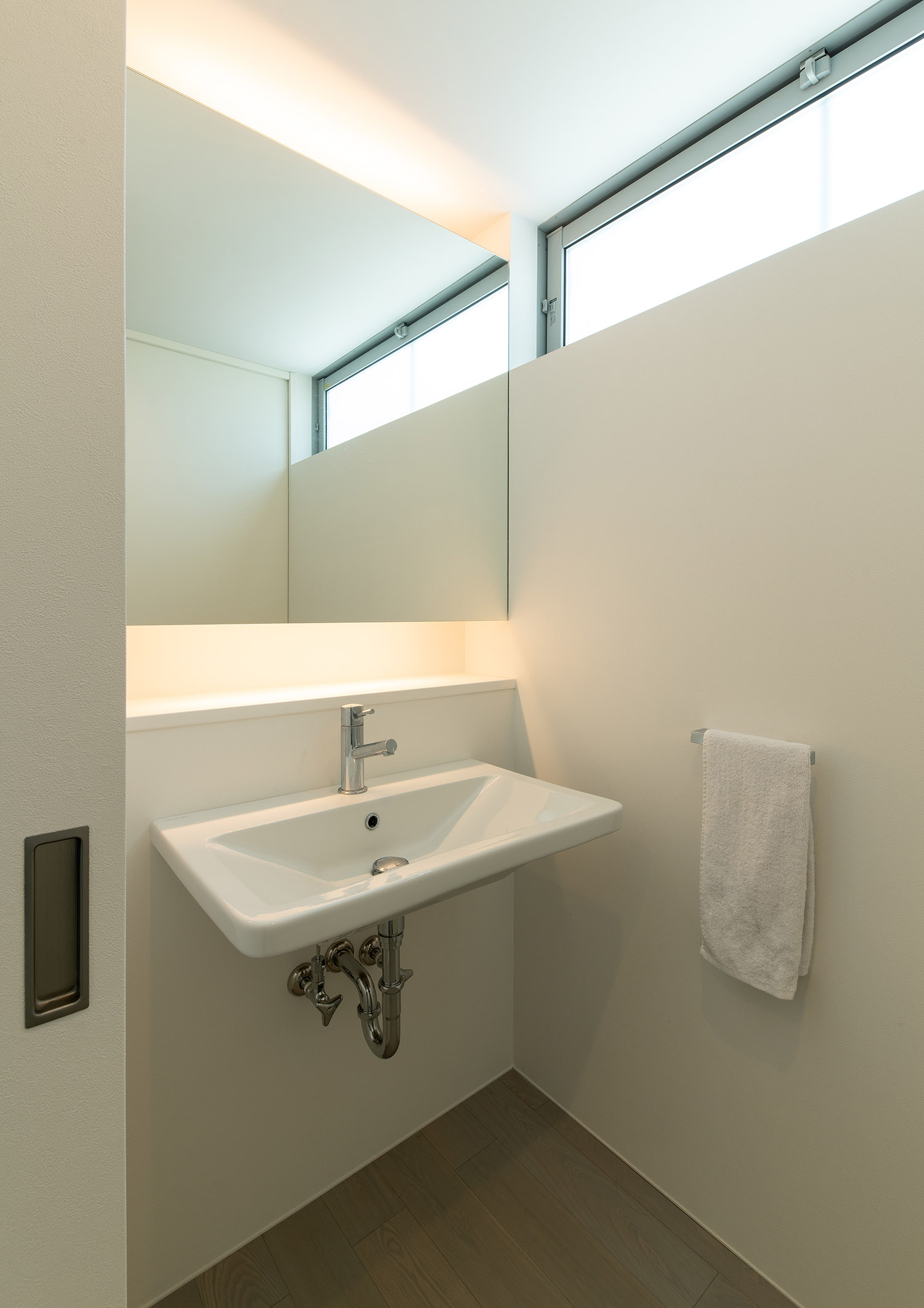 鏡の上下に間接照明が取り付けられたスリット窓のある洗面所・デザイン住宅 注文住宅・デザイン住宅建築実例_『CASE750 WHITE　GATE』_浴室・洗面所