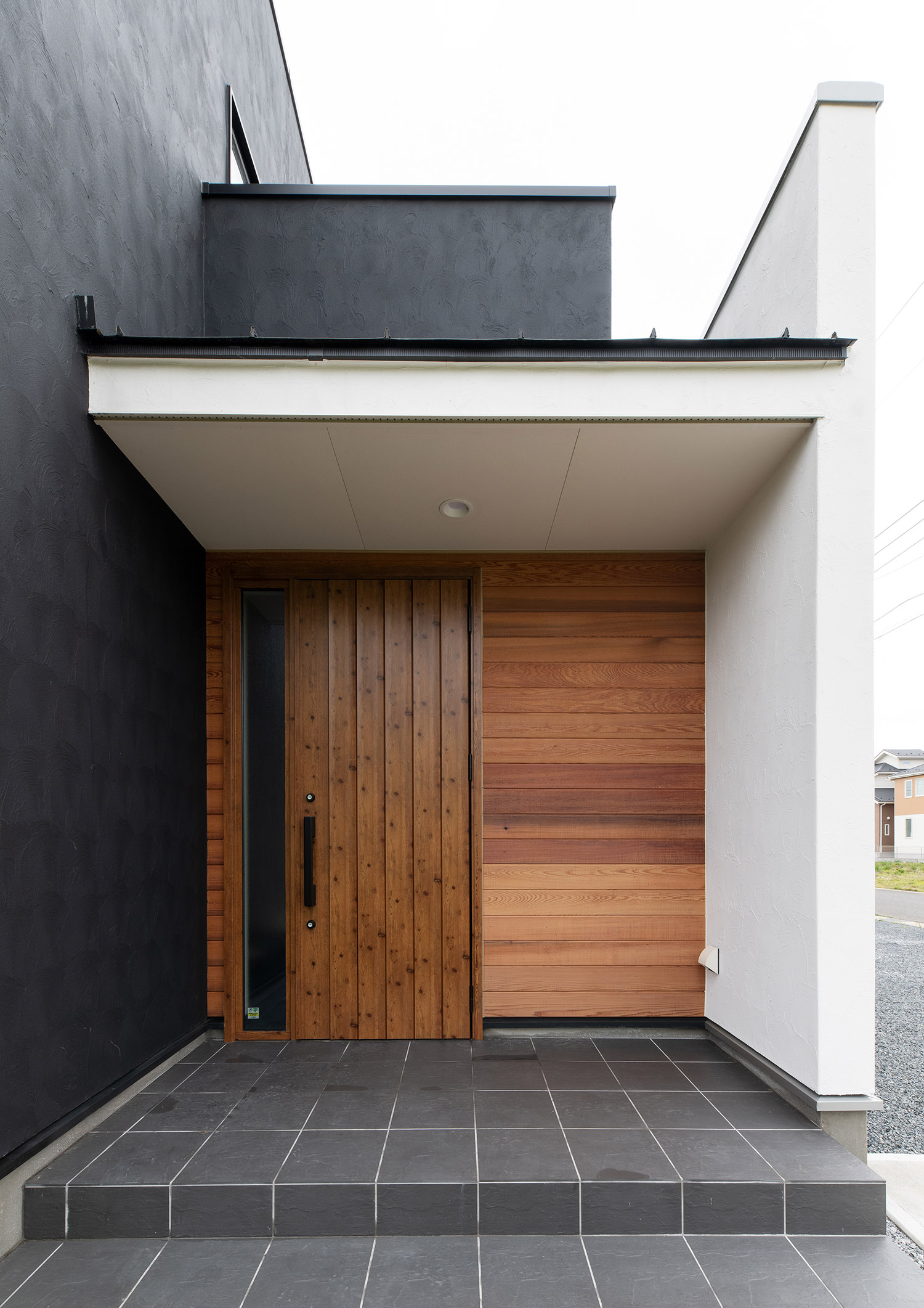 壁と扉が木で統一された、軒天井のある玄関ポーチ・デザイン住宅 注文住宅・デザイン住宅建築実例_『CASE751 Contarst』_外観