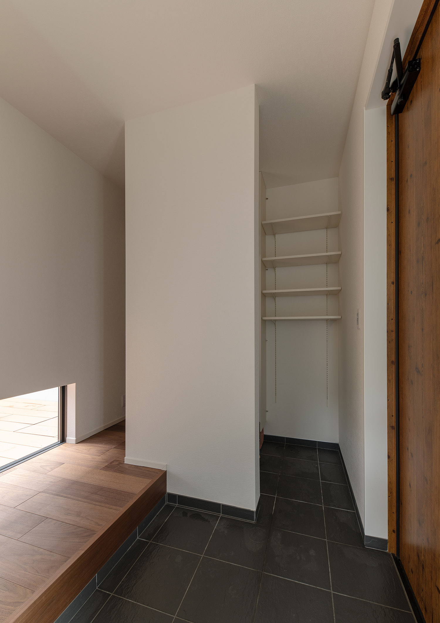 シューズインクローゼットが繋がったグレーのタイルの玄関・デザイン住宅 注文住宅・デザイン住宅建築実例_『CASE751 Contarst』_玄関