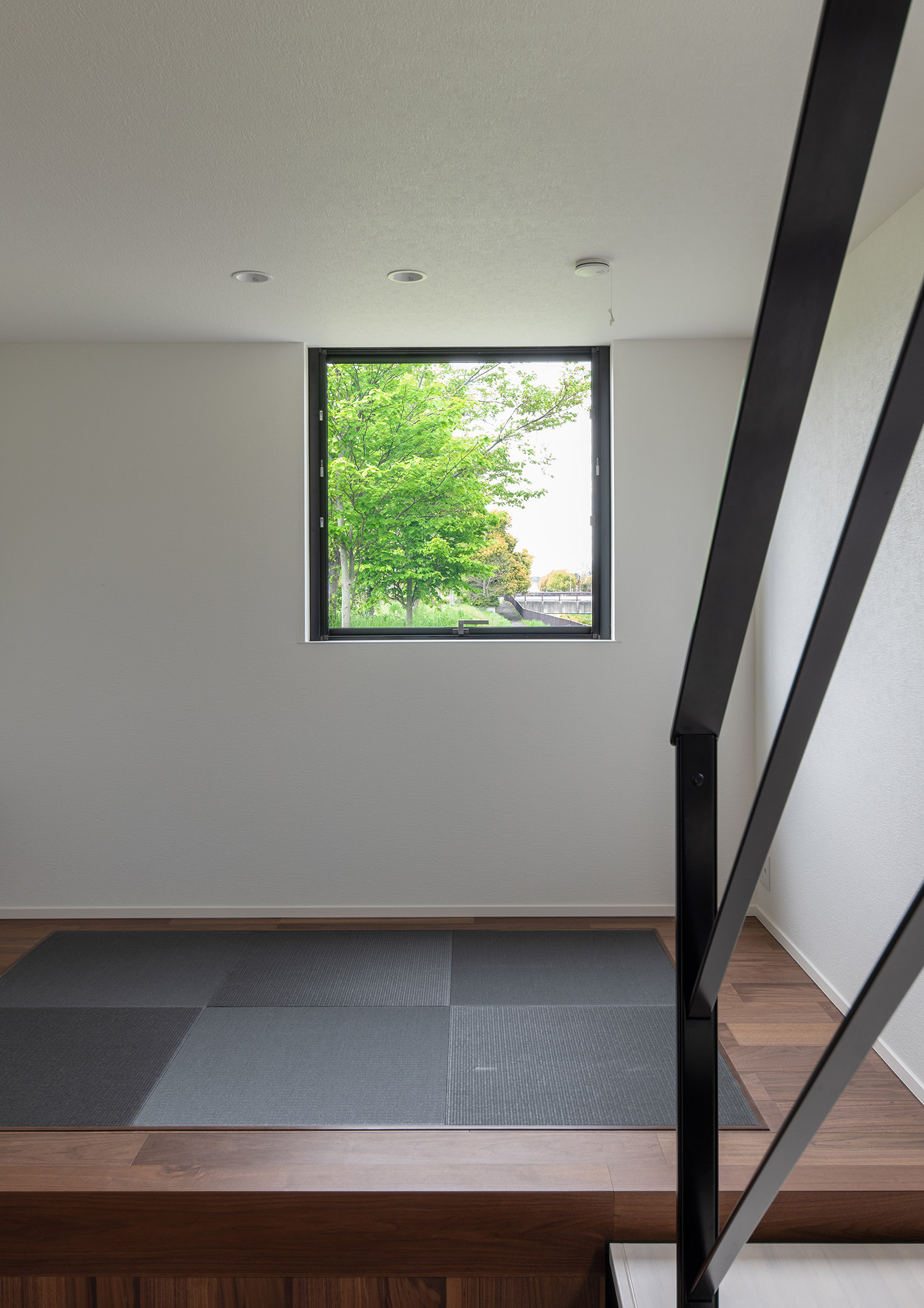 畳スペースのある壁に取り付けられた正方形の窓から外の緑が見える様子・デザイン住宅 注文住宅・デザイン住宅建築実例_『CASE751 Contarst』_和室