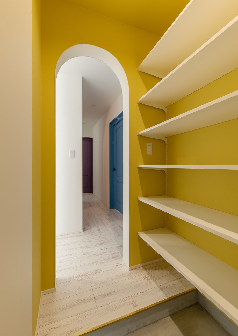 アーチ壁の入口で黄色のクロスのシューズインクローゼット・デザイン住宅 注文住宅・デザイン住宅建築実例_『CASE752 as CANVAS』_玄関