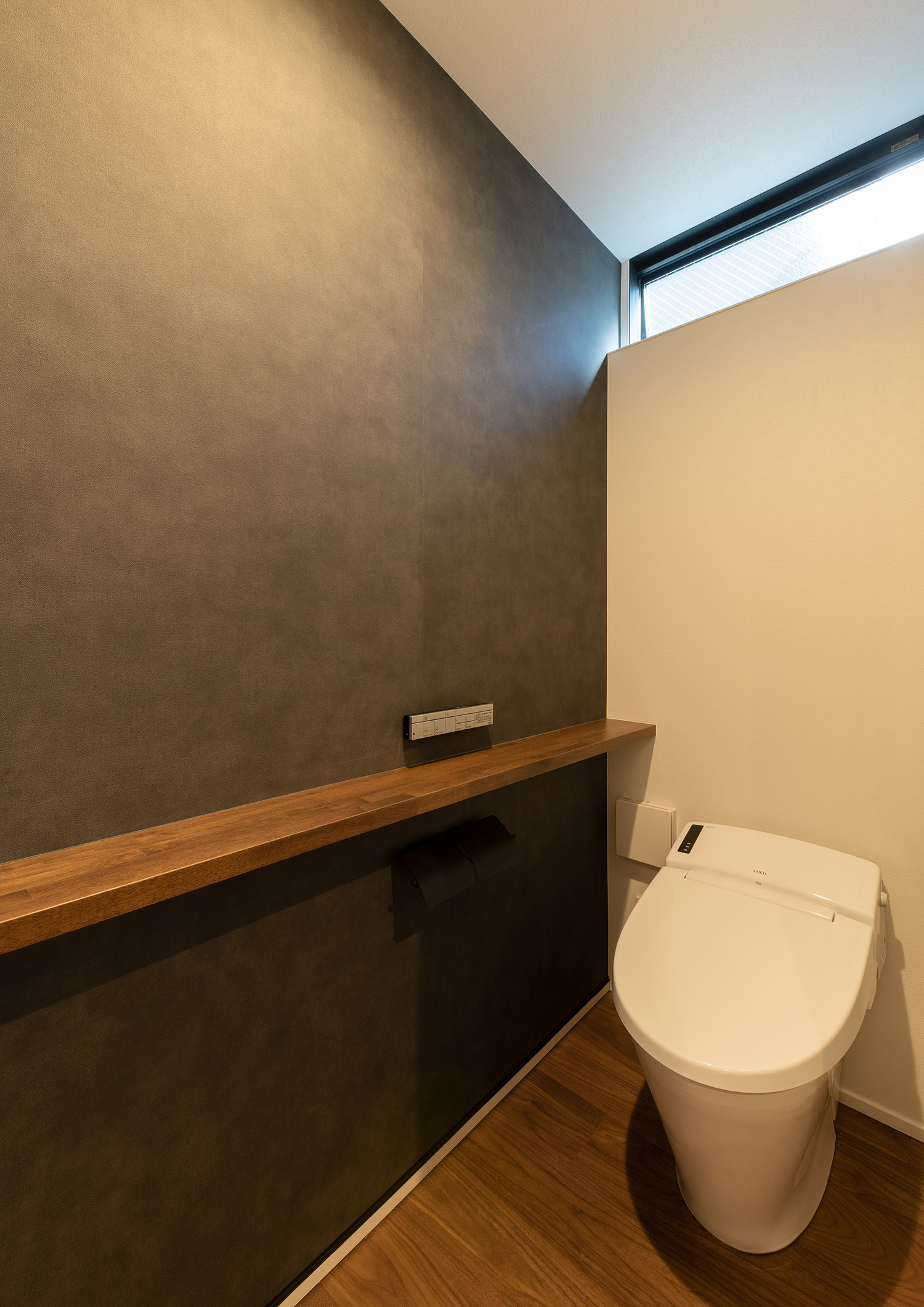 グレーのクロスで、ハイサイドライトや木のカウンターを設けたトイレ・デザイン住宅 注文住宅・デザイン住宅建築実例_『CASE753 円佇の家（えんていのいえ）』_トイレ
