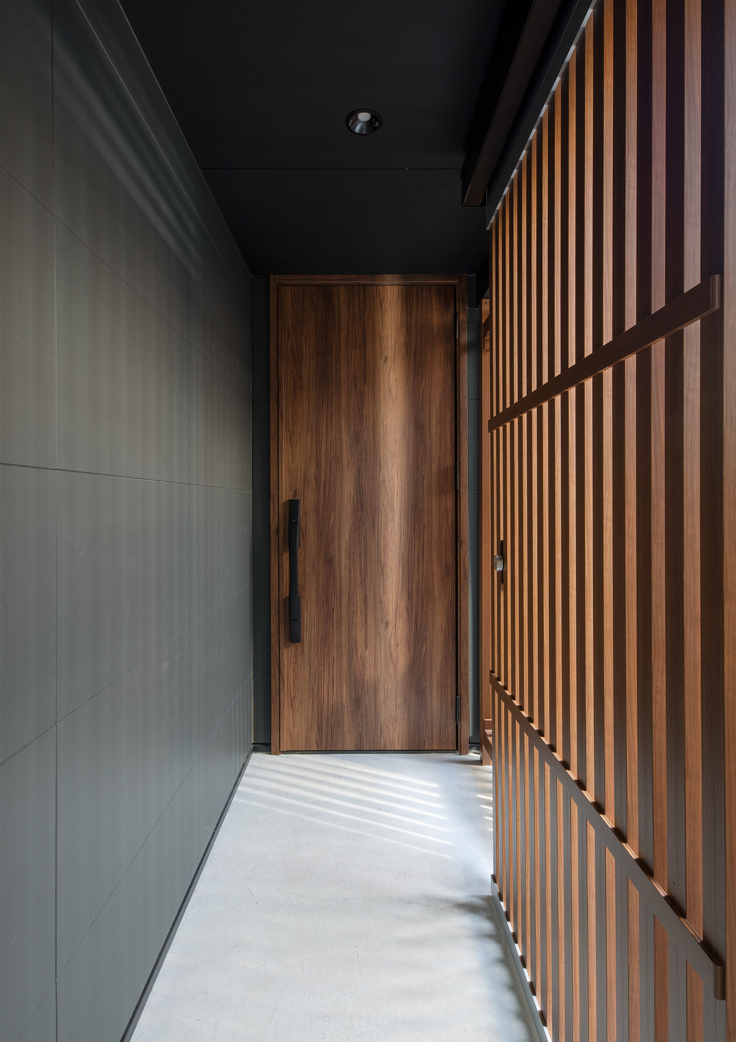 木のルーバーの壁のアプローチの先にある木の玄関扉・デザイン住宅 注文住宅・デザイン住宅建築実例_『CASE753 円佇の家（えんていのいえ）』_外観