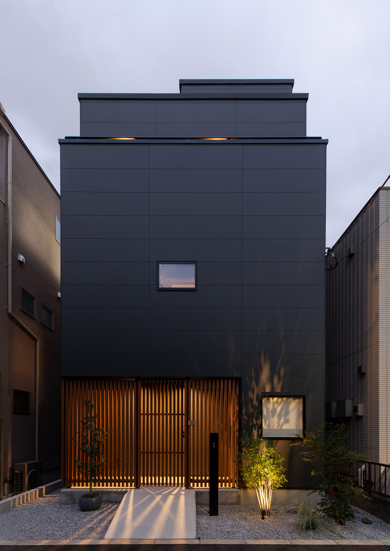 植栽が屋外照明に照らされた、木のルーバーから光が漏れる家・デザイン住宅 注文住宅・デザイン住宅建築実例_『CASE753 円佇の家（えんていのいえ）』_外観