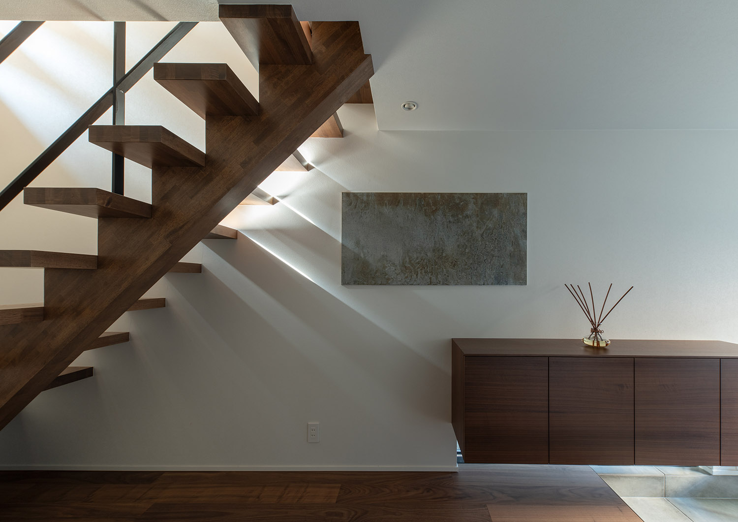 下に地窓を設けた浮いたデザインのシューズボックスや、木のスケルトン階段がある廊下・デザイン住宅 注文住宅・デザイン住宅建築実例_『CASE753 円佇の家（えんていのいえ）』_玄関