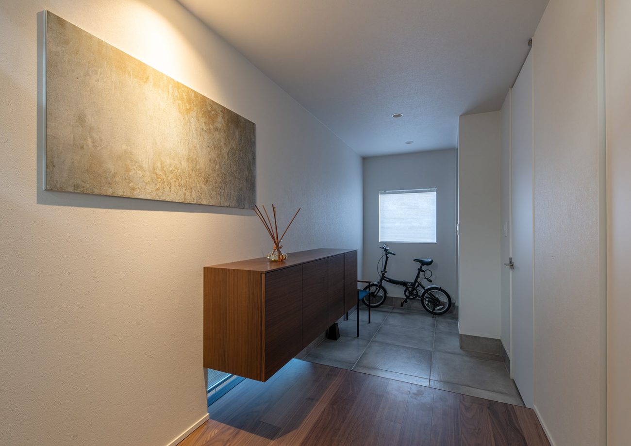 自転車を置くスペースがある、浮いたデザインのシューズボックスがある玄関・デザイン住宅 注文住宅・デザイン住宅建築実例_『CASE753 円佇の家（えんていのいえ）』_玄関