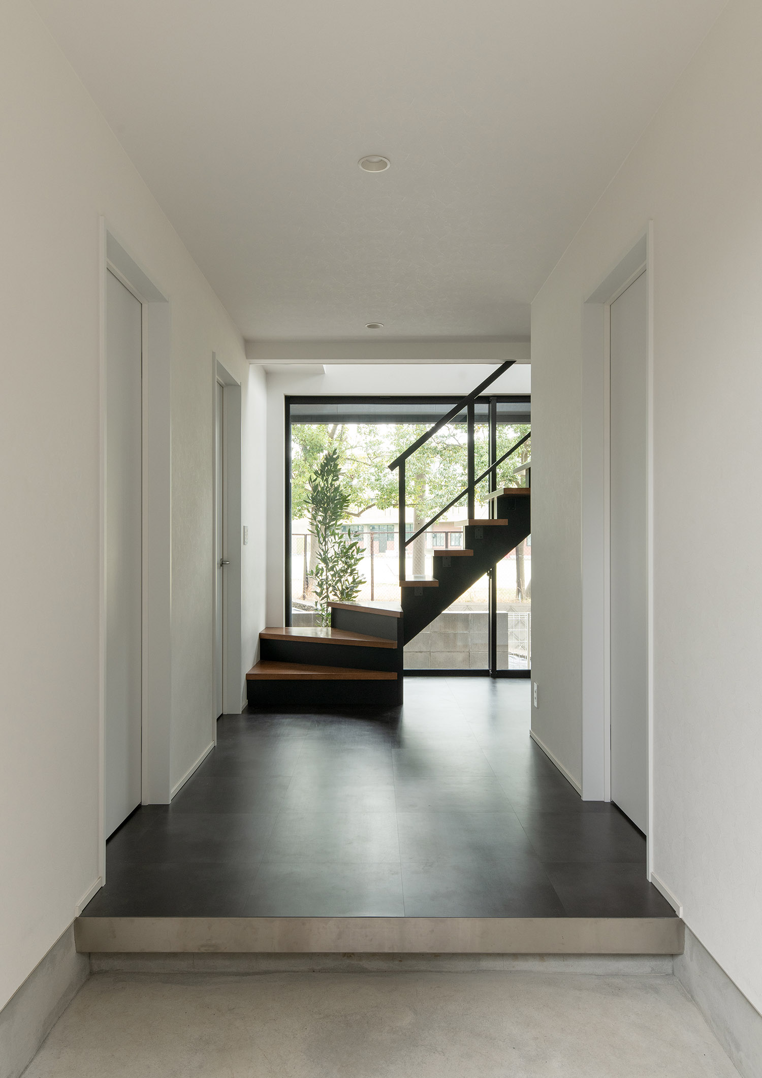 玄関の先にスケルトン階段と、外が見える大きな窓がある様子・デザイン住宅 注文住宅・デザイン住宅建築実例_『CASE755 山際の家（やまぎわのいえ）』_玄関