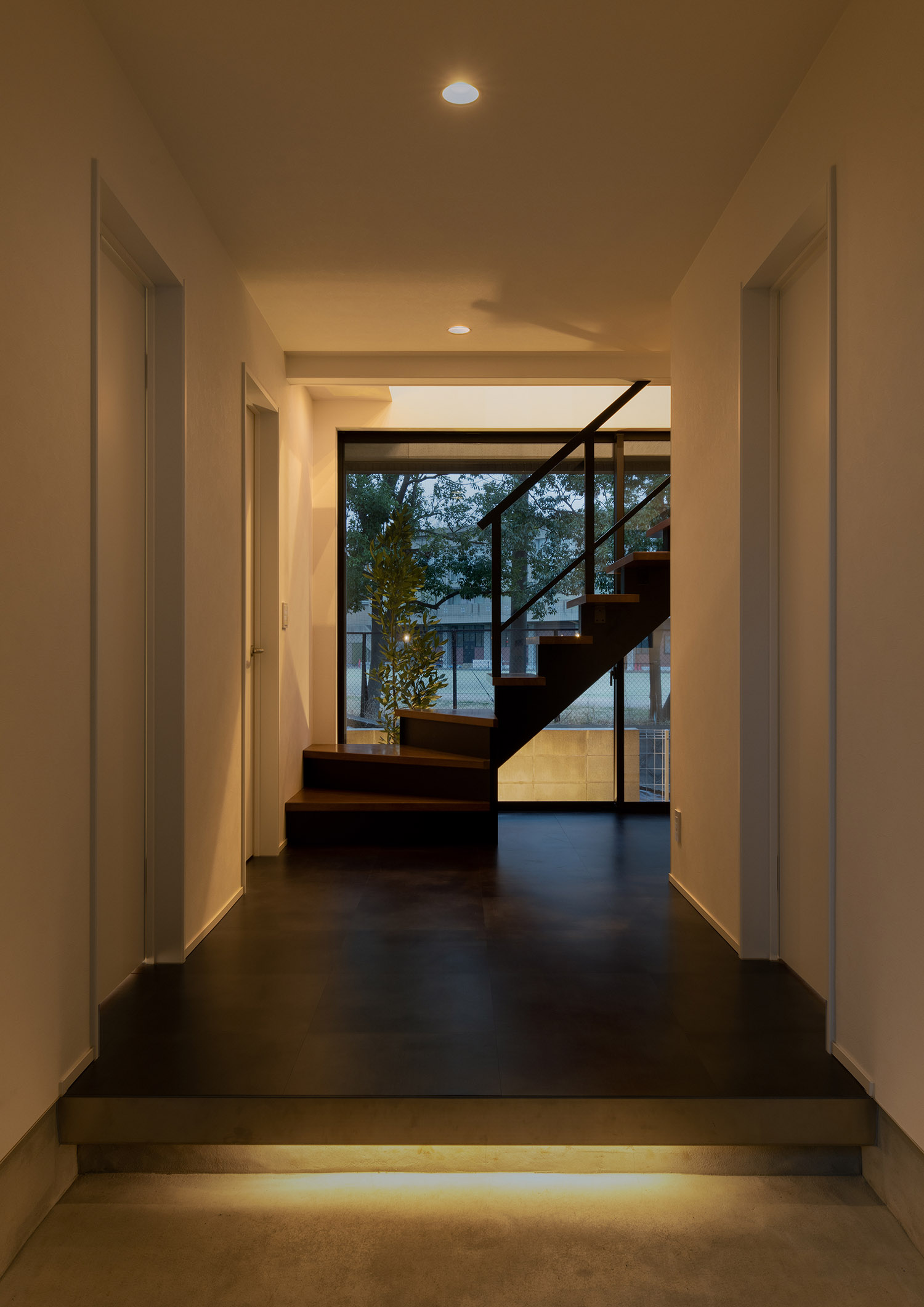 足元に間接照明が取り付けられ、正面にスケルトン階段がある玄関・デザイン住宅 注文住宅・デザイン住宅建築実例_『CASE755 山際の家（やまぎわのいえ）』_玄関