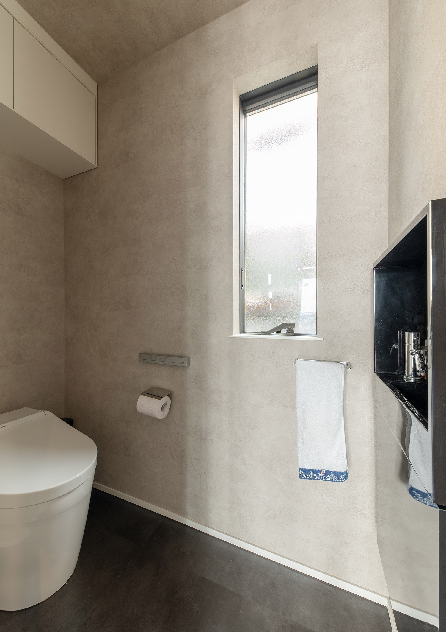 ベージュのクロスで、黒い薄型手洗いが置かれたトイレ。 注文住宅・デザイン住宅建築実例_『CASE755 山際の家（やまぎわのいえ）』_トイレ