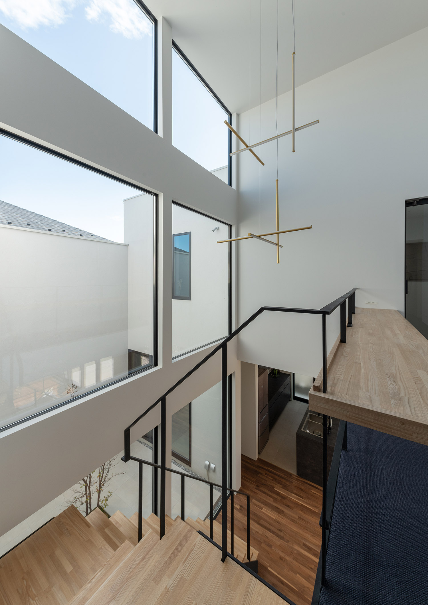 吹き抜けの天井からライン状のペンダントライトが取り付けられている様子・デザイン住宅 注文住宅・デザイン住宅建築実例_『CASE756 utsuwa』_階段