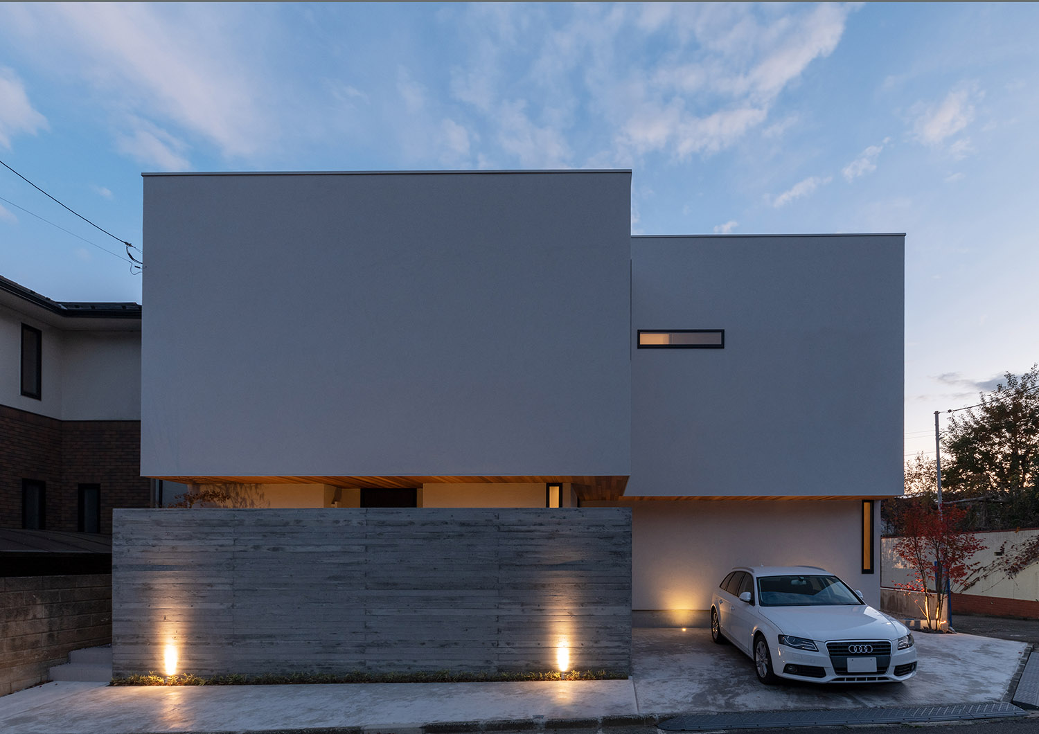 地面に照明が取り付けられたコンクリートの目隠し壁がある白い外壁の住宅・デザイン住宅 注文住宅・デザイン住宅建築実例_『CASE756 utsuwa』_外観