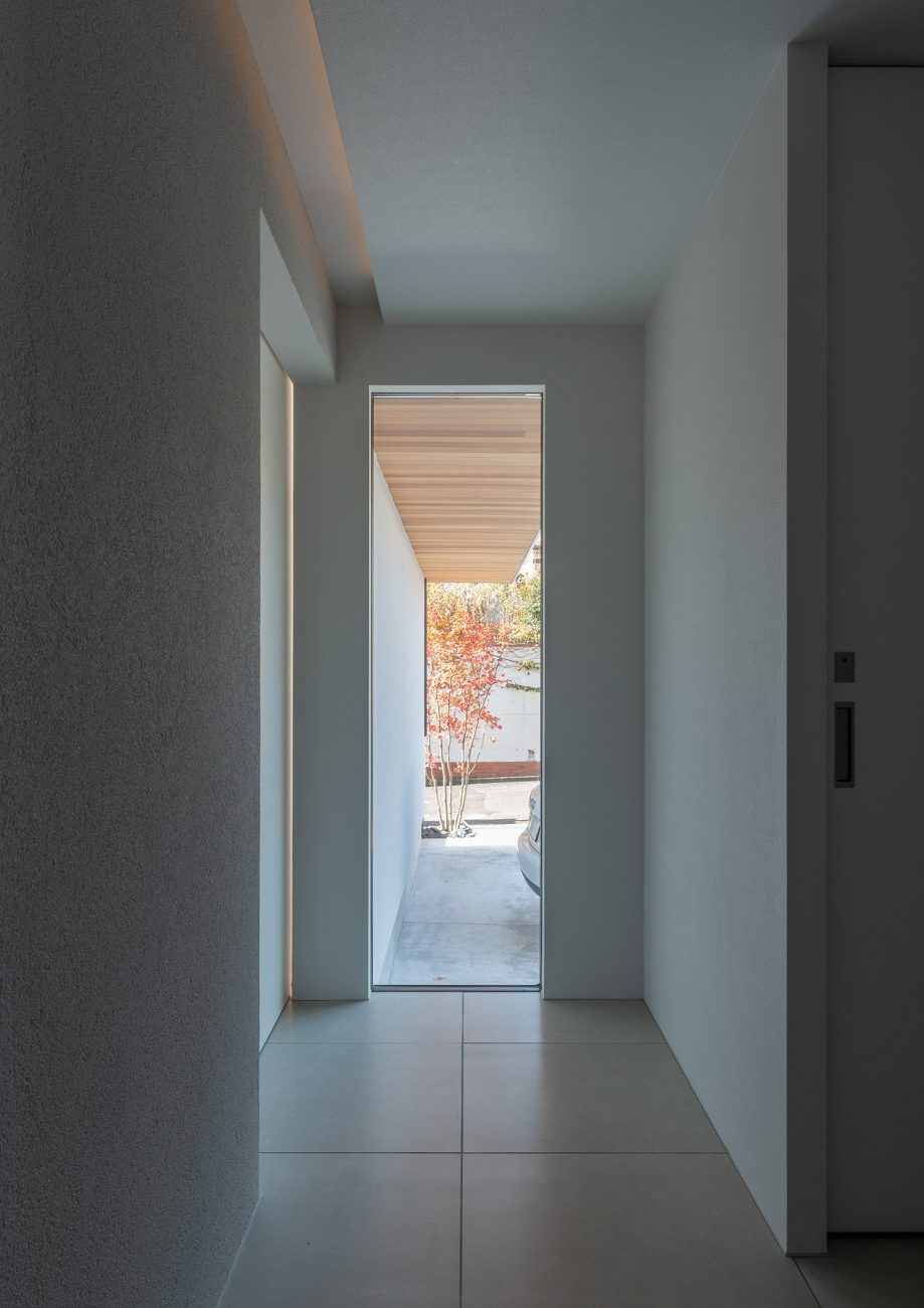 スリット窓から木目の軒天井や植栽が見えるタイルの玄関・デザイン住宅 注文住宅・デザイン住宅建築実例_『CASE756 utsuwa』_玄関