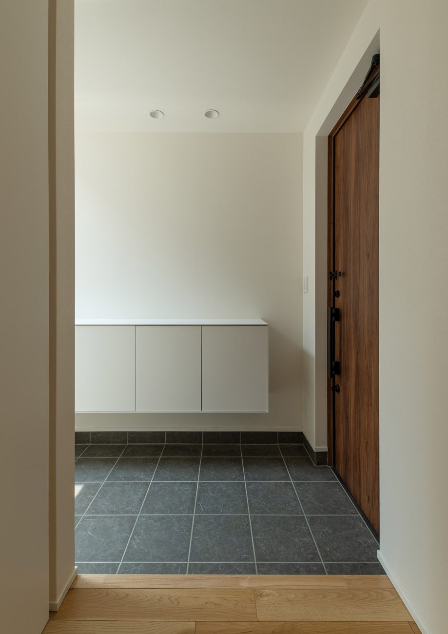 浮いたデザインの白い収納ボックスを取り付けたグレーのタイル玄関・デザイン住宅 注文住宅・デザイン住宅建築実例_『CASE759 陽光照らすイエ』_玄関