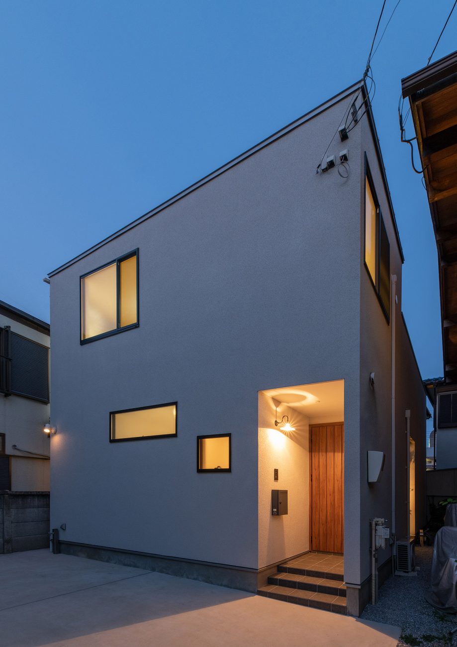 白い外壁の住まいの玄関ポーチが照明に照らされる様子・デザイン住宅 注文住宅・デザイン住宅建築実例_『CASE759 陽光照らすイエ』_外観