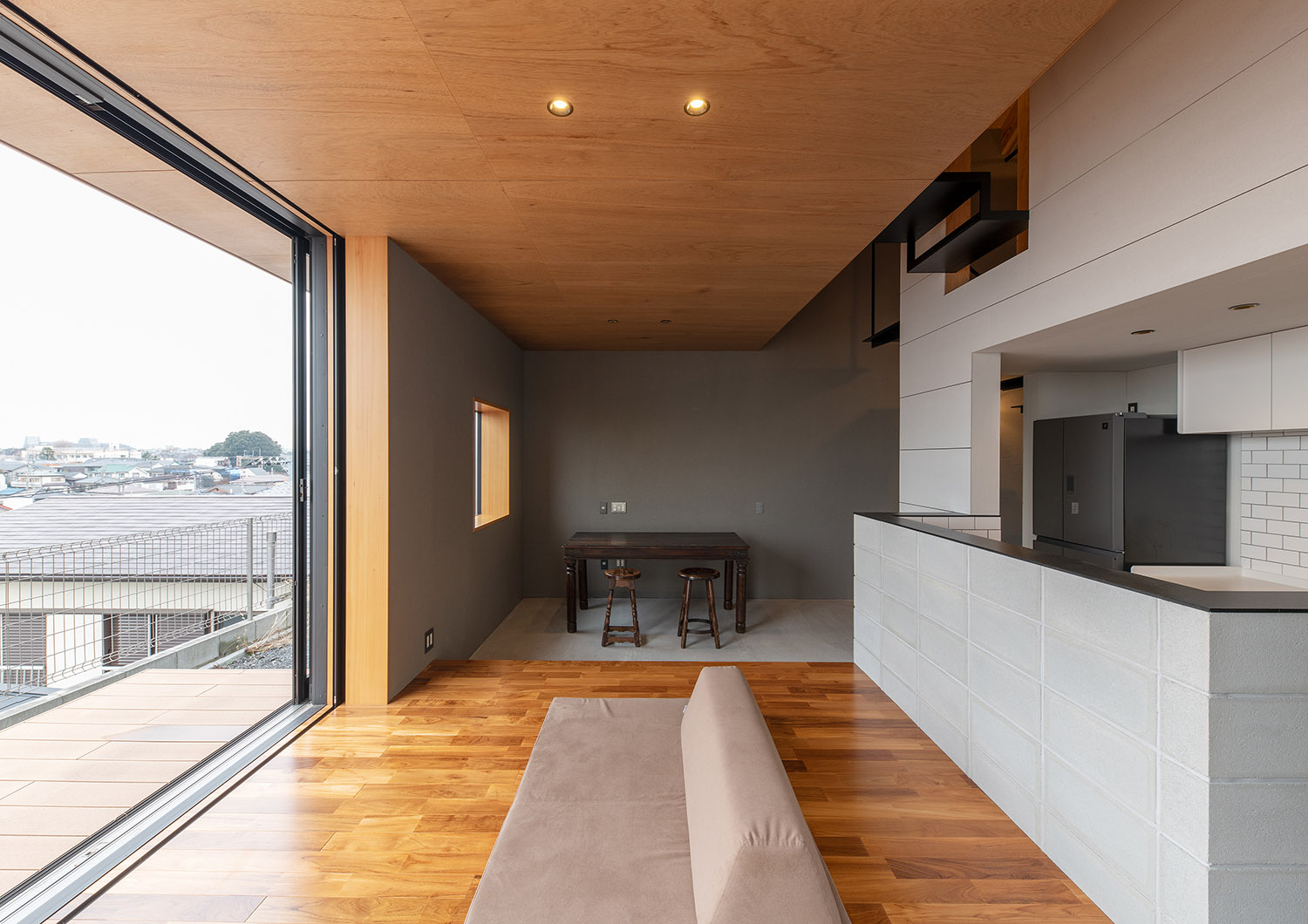 木目の天井でフローリングの空間からテーブルを置いた土間を見た様子・デザイン住宅 注文住宅・デザイン住宅建築実例_『CASE760 自然体の家』_LDK