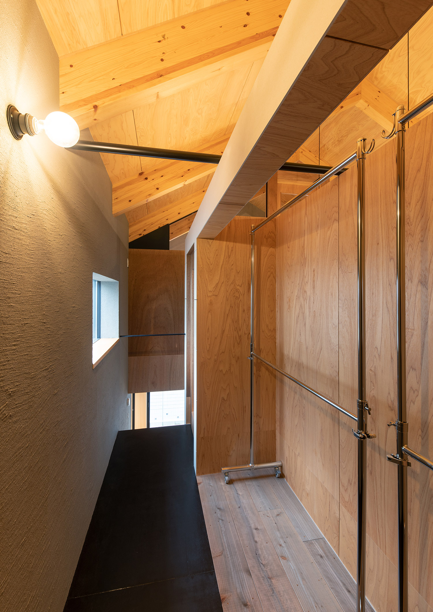 ハンガーラックを置いた木の壁に囲まれたウォークインクローゼット・デザイン住宅 注文住宅・デザイン住宅建築実例_『CASE760 自然体の家』_寝室