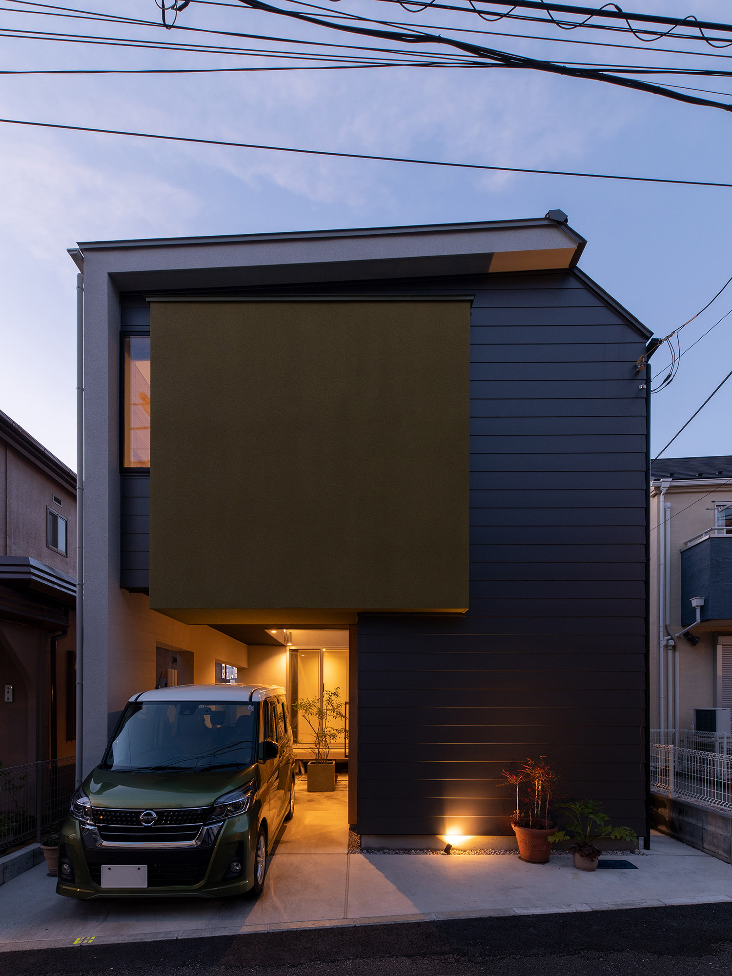 駐車場の奥にある中庭から光が漏れるスクエアな外観の家・デザイン住宅 注文住宅・デザイン住宅建築実例_『CASE761 光と明かりの交錯』_外観