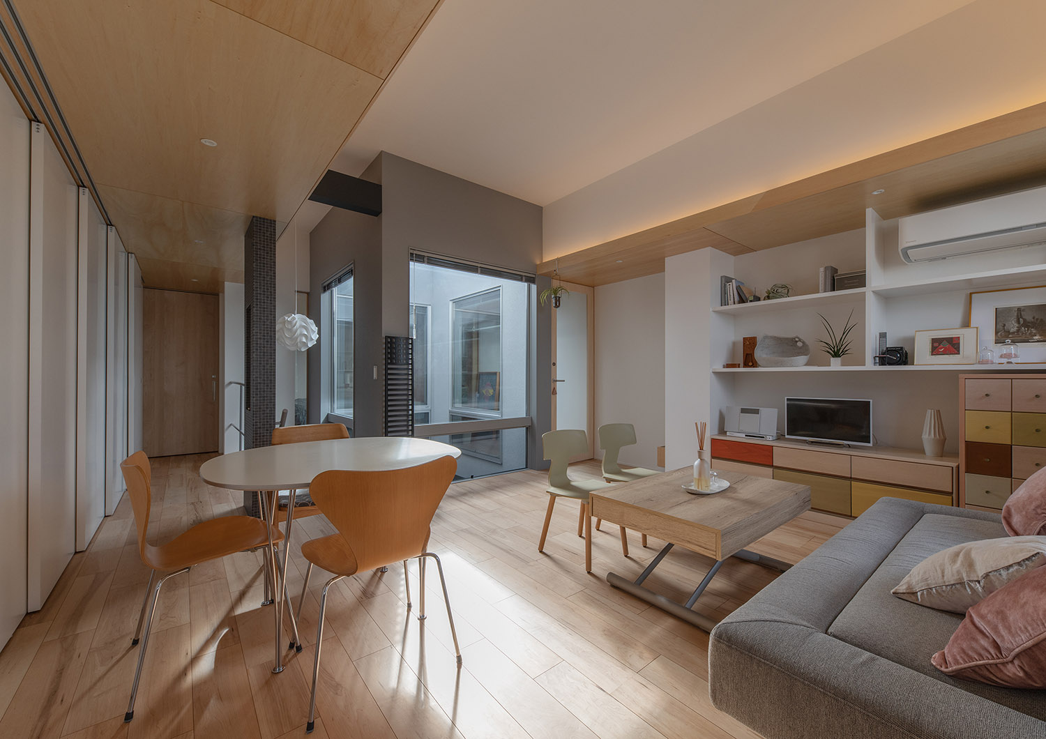 3つの素材を組み合わせた外観と中庭越しに光が差し込む住まい