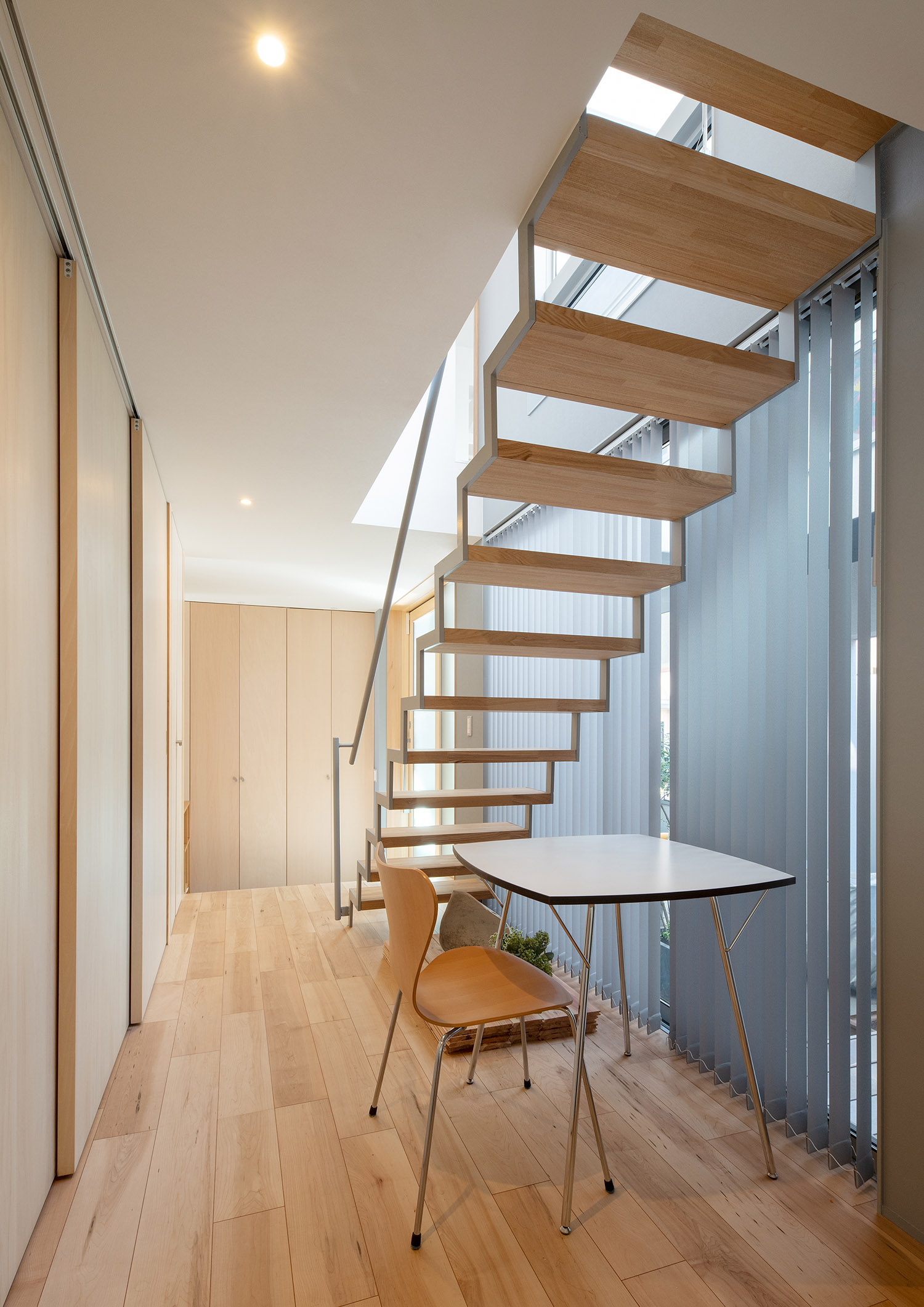 スケルトン階段下のスペースに置かれた椅子と机・デザイン住宅 注文住宅・デザイン住宅建築実例_『CASE761 光と明かりの交錯』_階段