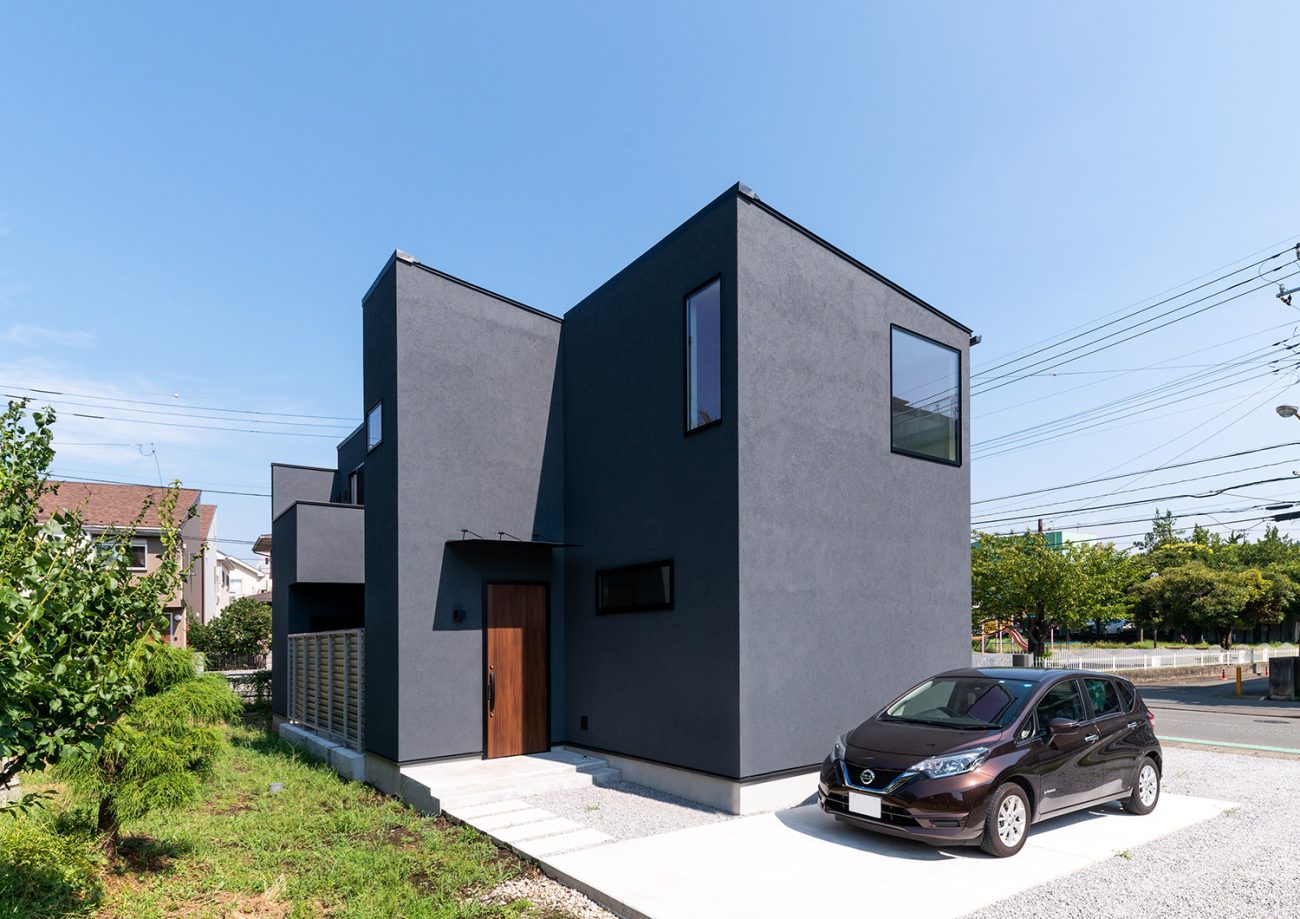 黒い外壁の家の前に車が一台止められている様子・デザイン住宅 注文住宅・デザイン住宅建築実例_『CASE763 ソト黒ウチ白』_外観