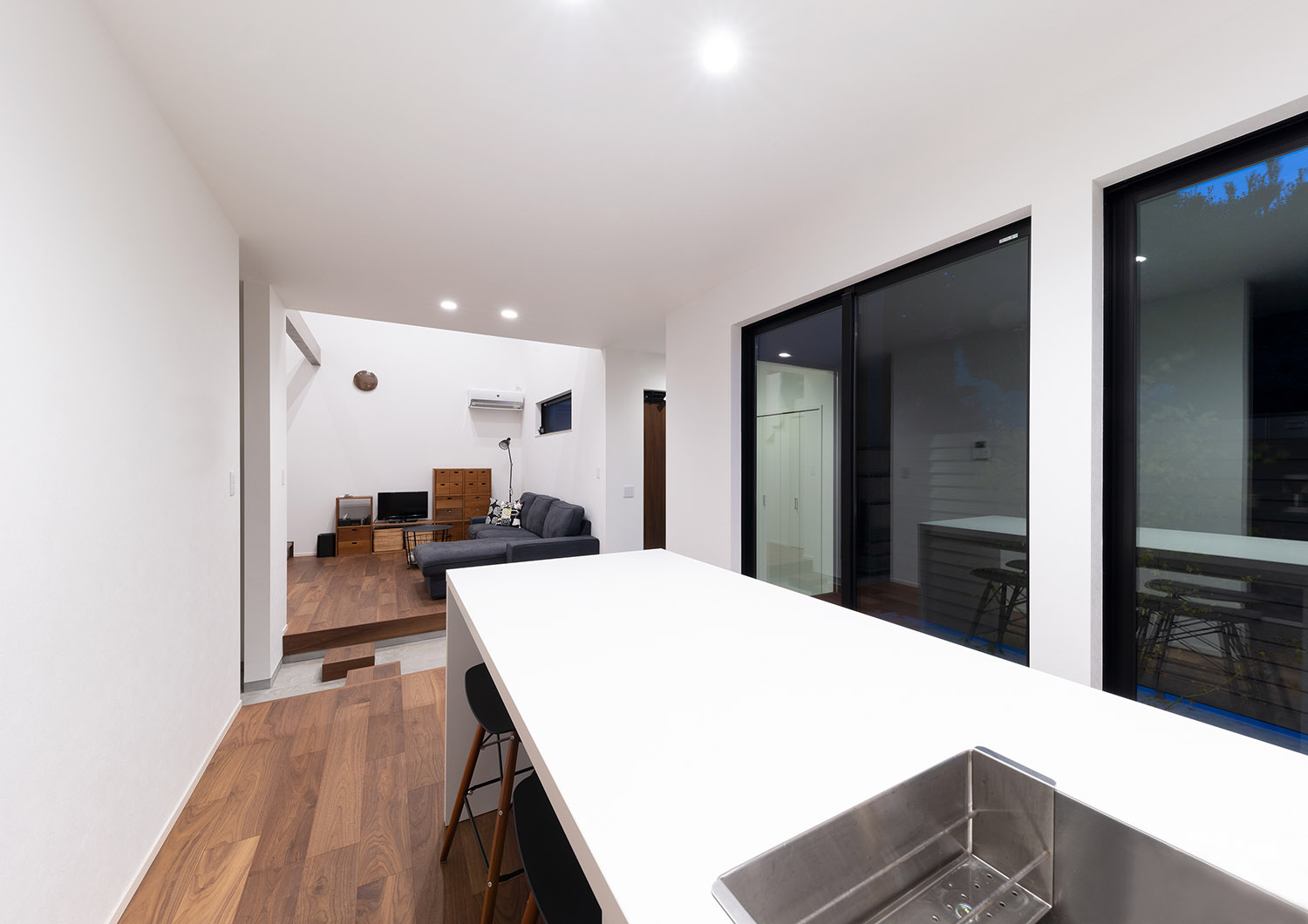 白いキッチンがあるフローリングのシンプルなLDK・デザイン住宅 注文住宅・デザイン住宅建築実例_『CASE763 ソト黒ウチ白』_LDK