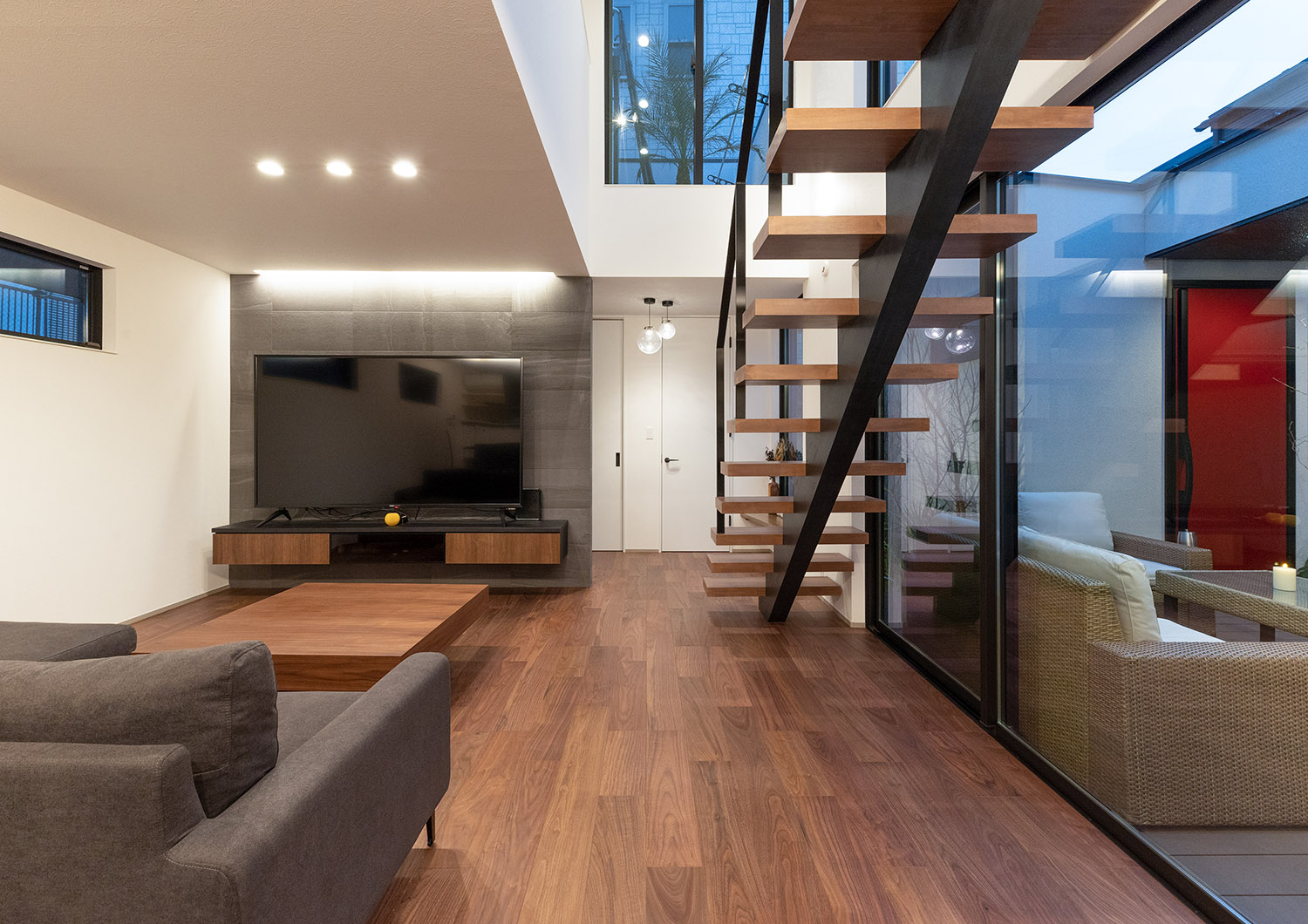 階段部分が吹き抜けになり、中庭とフラットに繋がるLDK・デザイン住宅 注文住宅・デザイン住宅建築実例_『CASE765 イロ色のイエ』_LDK