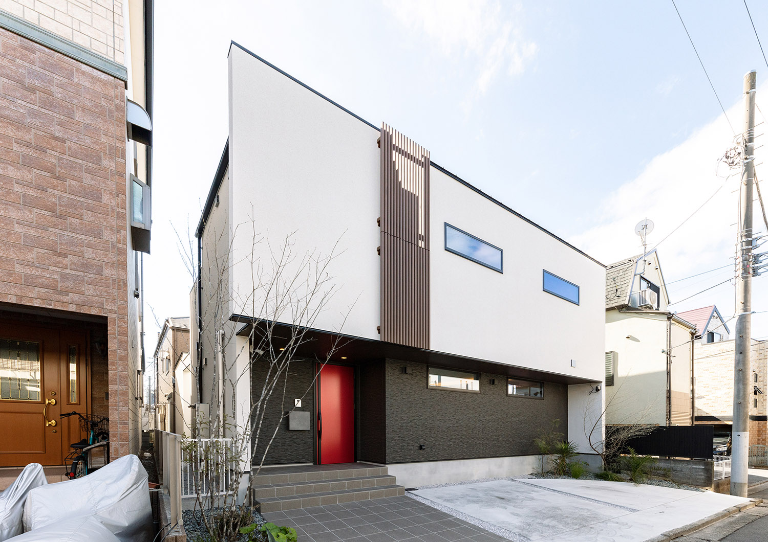 モノトーンの外壁に木のルーバーや赤い扉がアクセントとなった家・デザイン住宅 注文住宅・デザイン住宅建築実例_『CASE765 イロ色のイエ』_外観