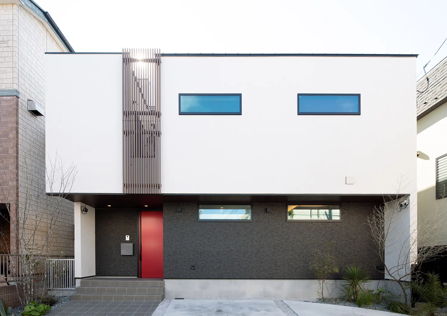 グレーに真っ赤な玄関がミステリアスな外観デザイン