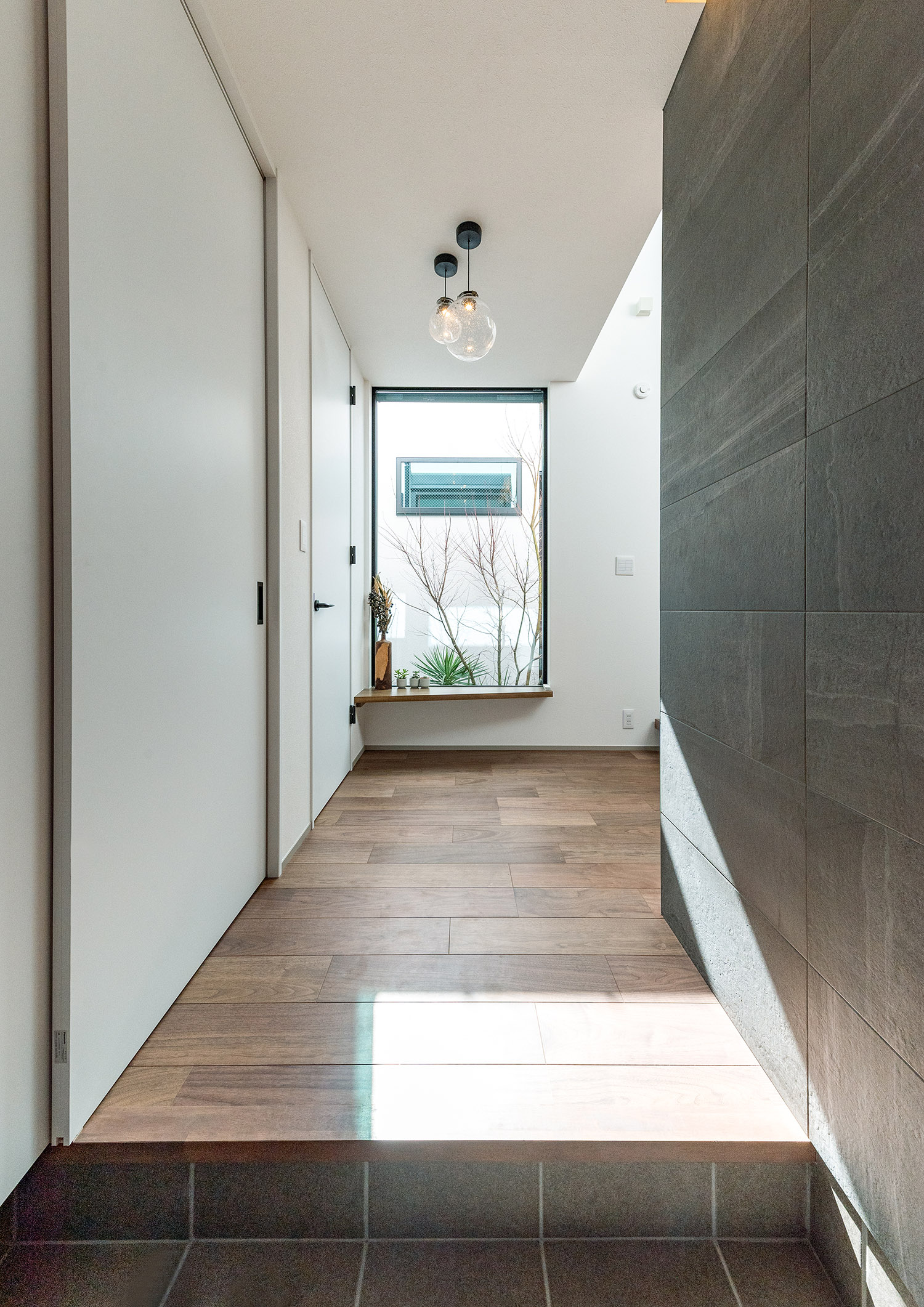 突き当りに窓が取り付けられた明るくナチュラルな玄関・デザイン住宅 注文住宅・デザイン住宅建築実例_『CASE765 イロ色のイエ』_玄関